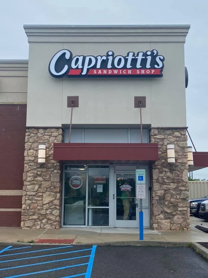 Front entrance of Capriotti's Sandwich Shop with signage and parking space.