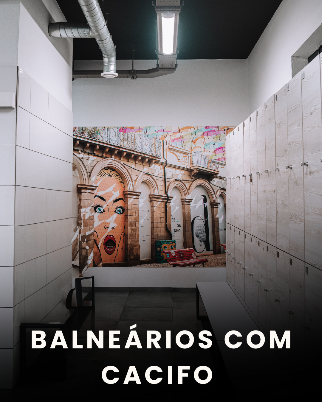 Sala de vestiários com lockers de madeira clara e uma parede decorada com arte de rua, incluindo uma mural de uma mulher com expressão surpresa e desenhos de guarda-chuvas coloridos no teto.