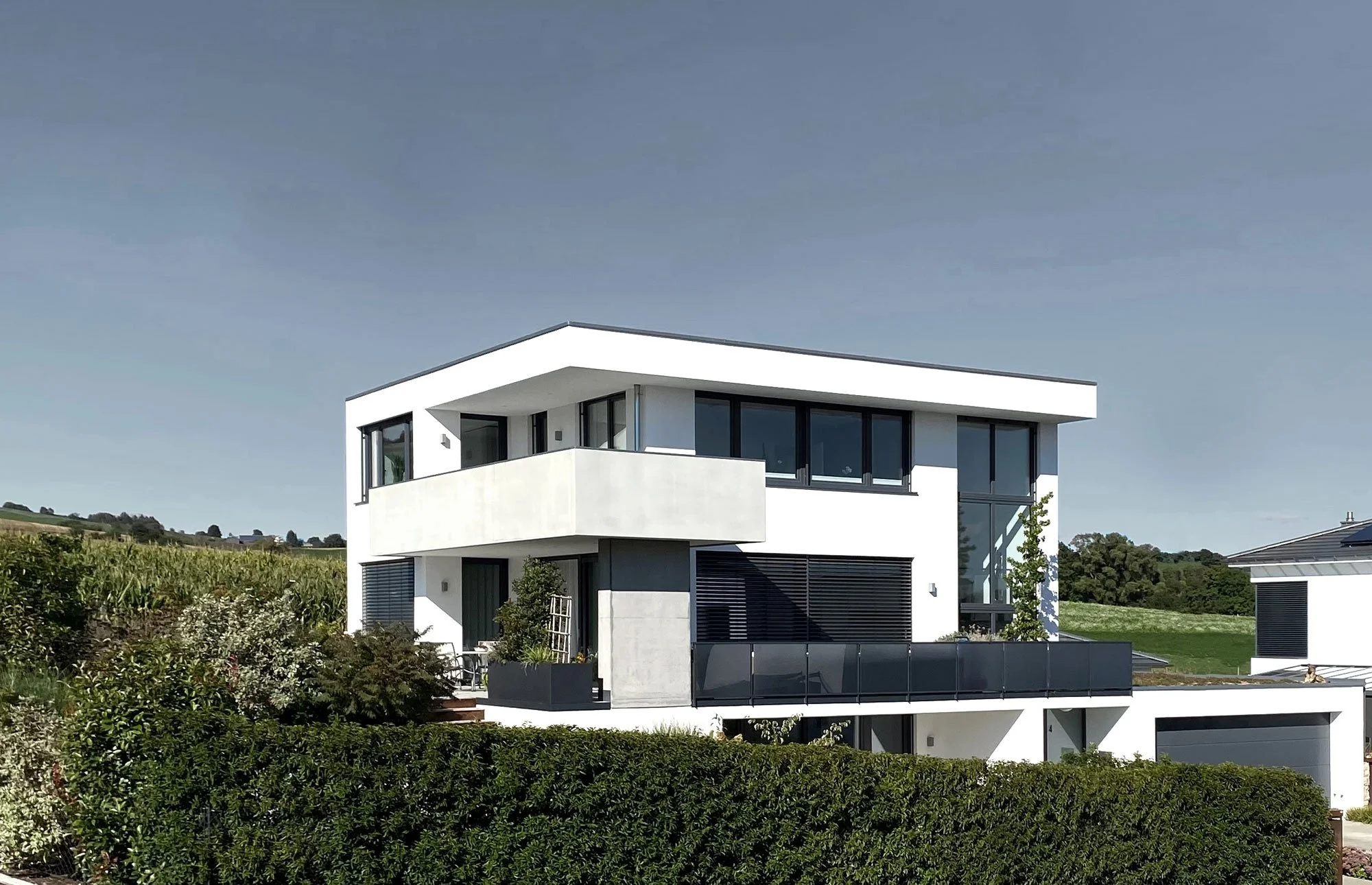 Modernes, weißes Haus mit großen Kunststoff-Fenstern in antharzit