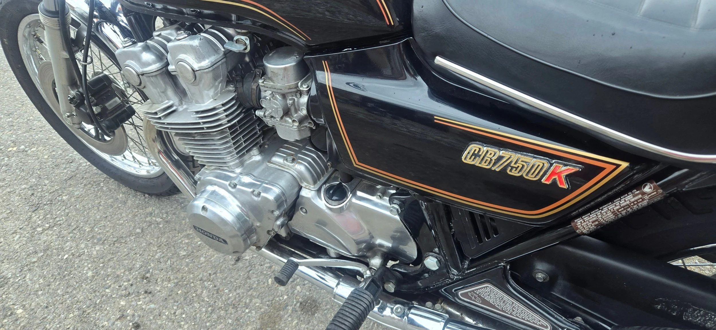 Close-up of a vintage black Honda CB750K motorcycle engine and frame, showing detailed engine parts and the bike's model badge.