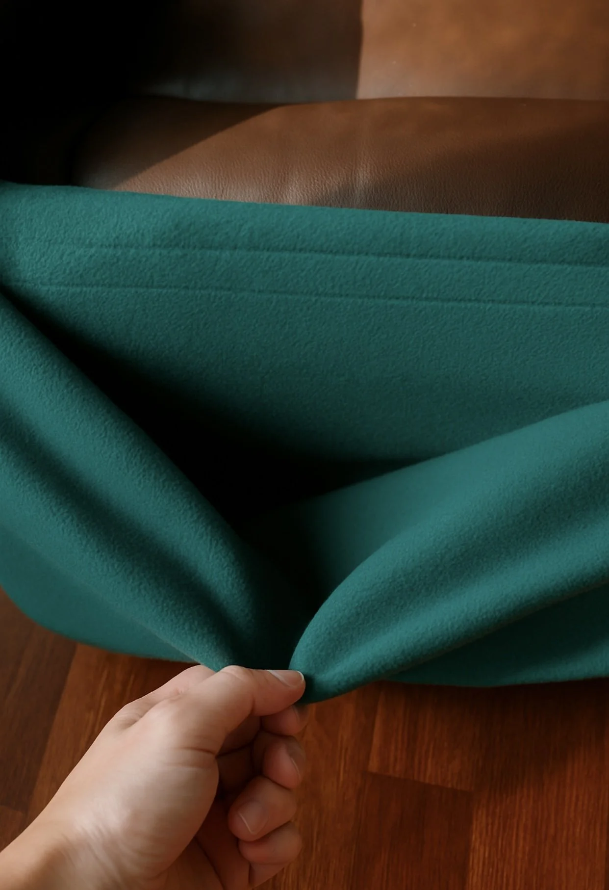 A human hand holds the NestHug pouch open, showing the inside.