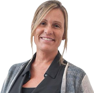 Mujer sonriente con cabello rubio y chaqueta de mezclilla, de pie contra fondo blanco.