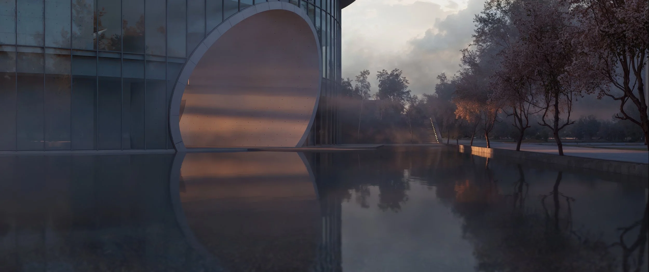 Modern building with large round arch or window reflection in water, trees with fall foliage, and a pathway in the background during dusk or dawn.