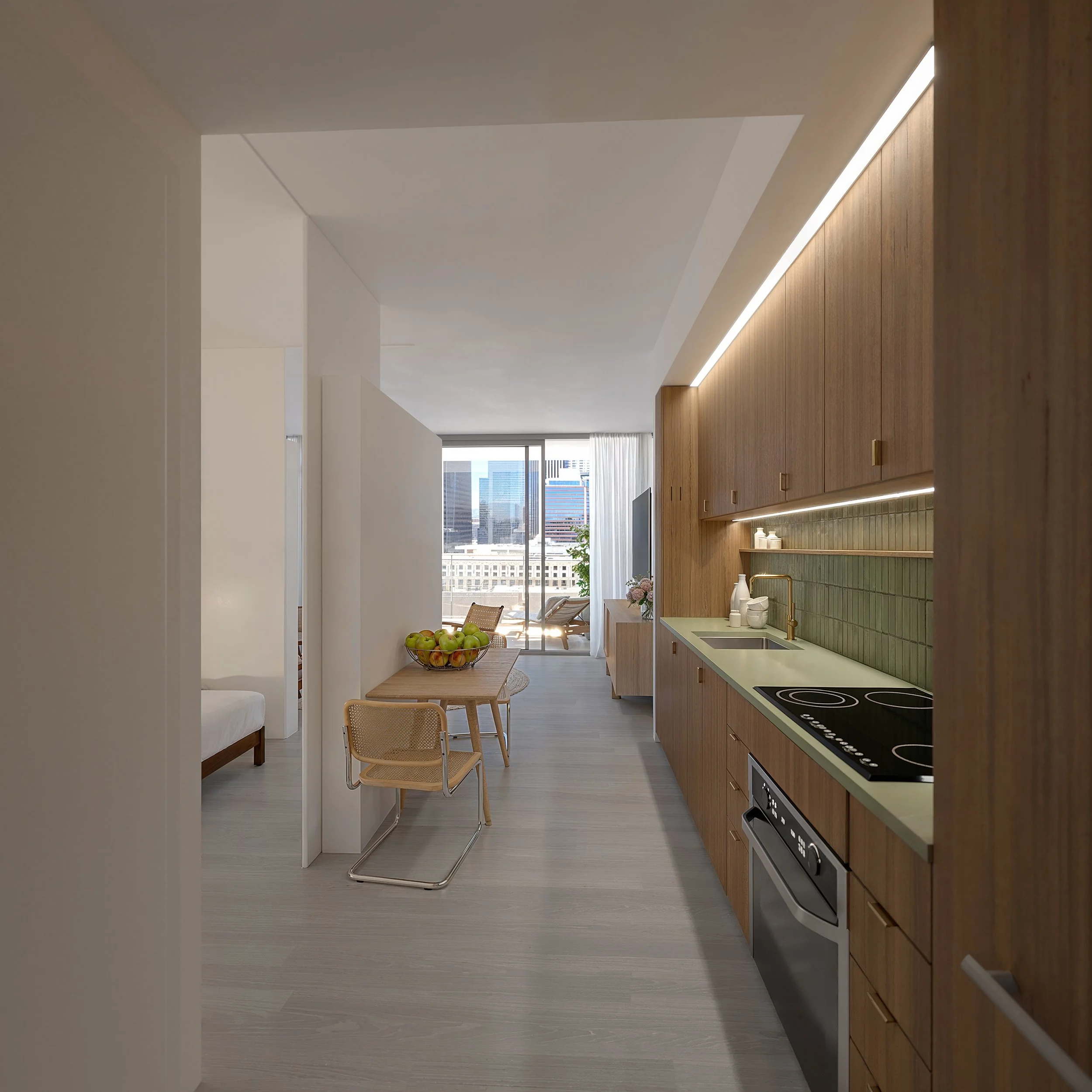 Modern kitchen and dining area in an apartment with wooden cabinets, a green backsplash, black electric stove, and a dining table with apples.