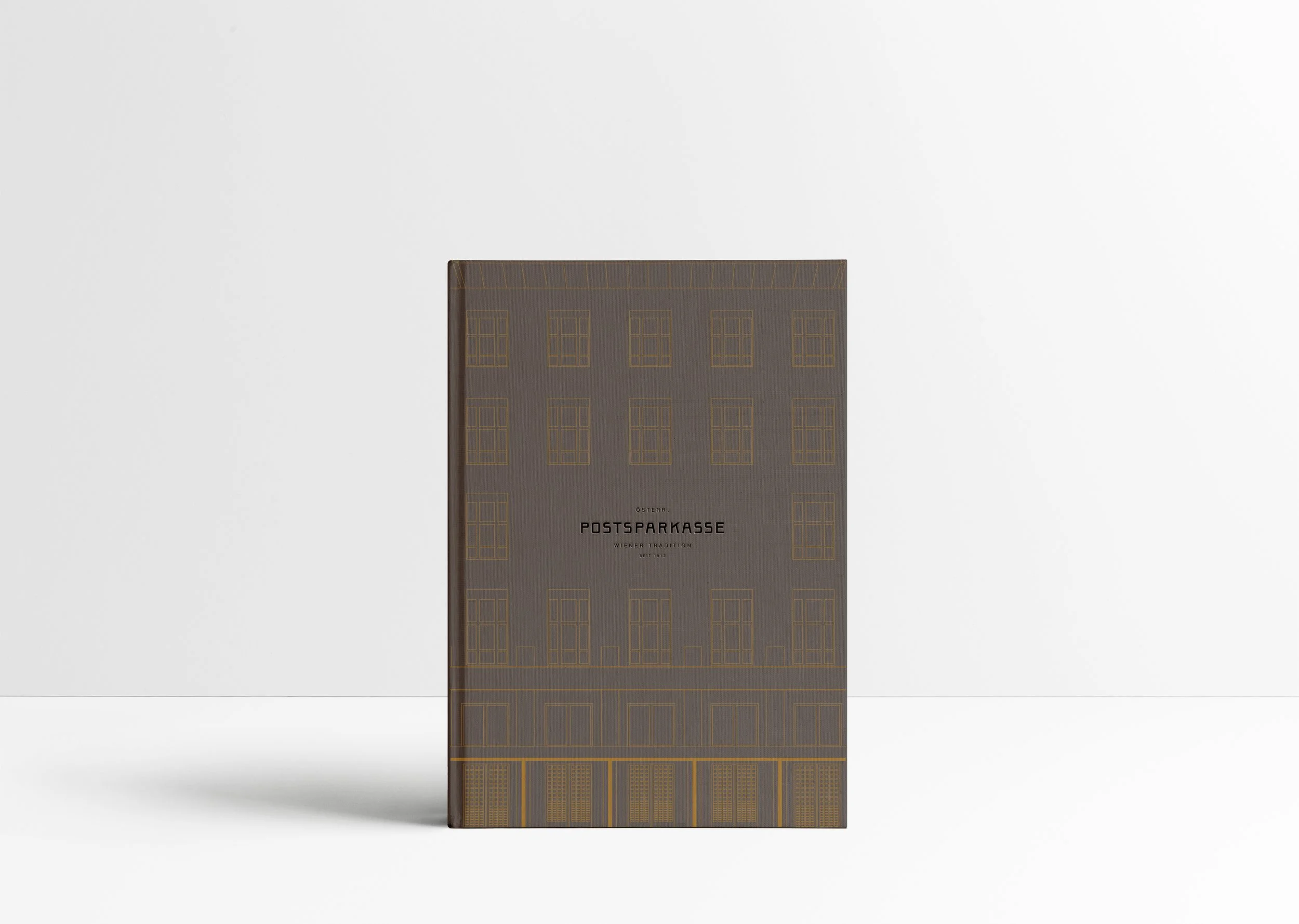 A dark book with a gold outline of building windows on the cover, titled "Postparkasse" with smaller text "Wiener Tradition" and the year 1912.