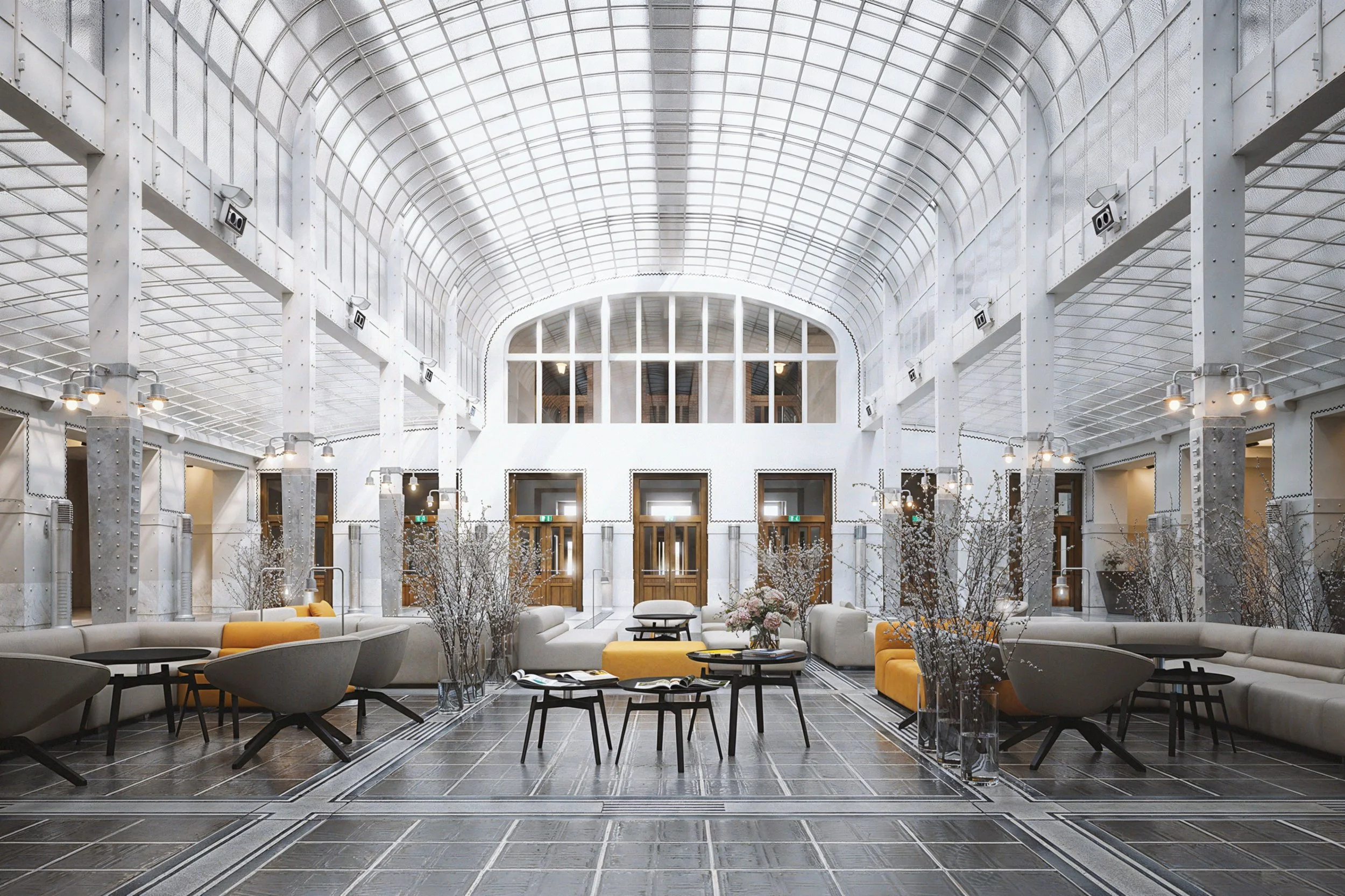 Modern spacious indoor lobby with high arched glass ceiling, beige sofas, gray chairs, small tables, and decorative branches in vases.