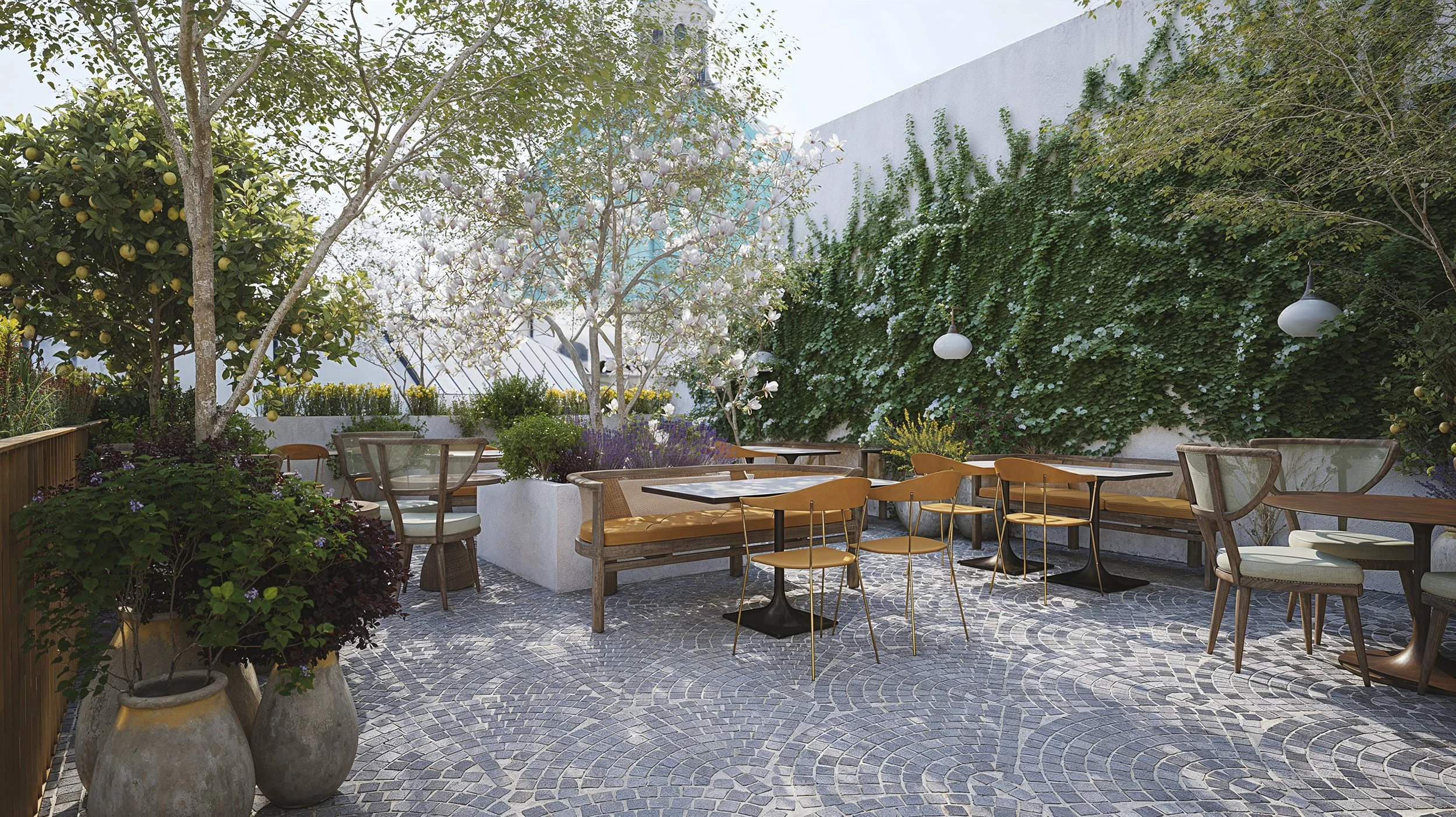 Outdoor patio with tables and chairs, surrounded by trees and plants, with a textured stone floor and a vine-covered wall.