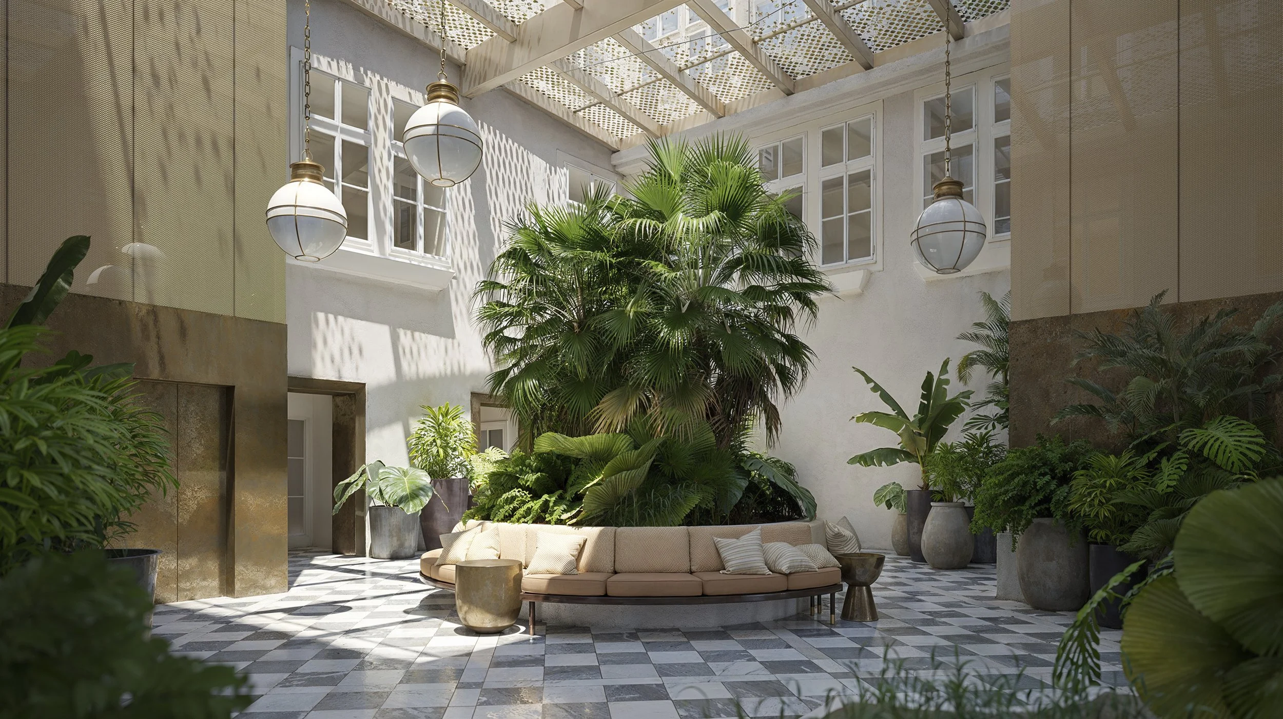 Indoor courtyard with large central tropical plant, white walls, hanging lights, black and white checkered tile floor, curved beige sofa with pillows, and potted plants along the perimeter.