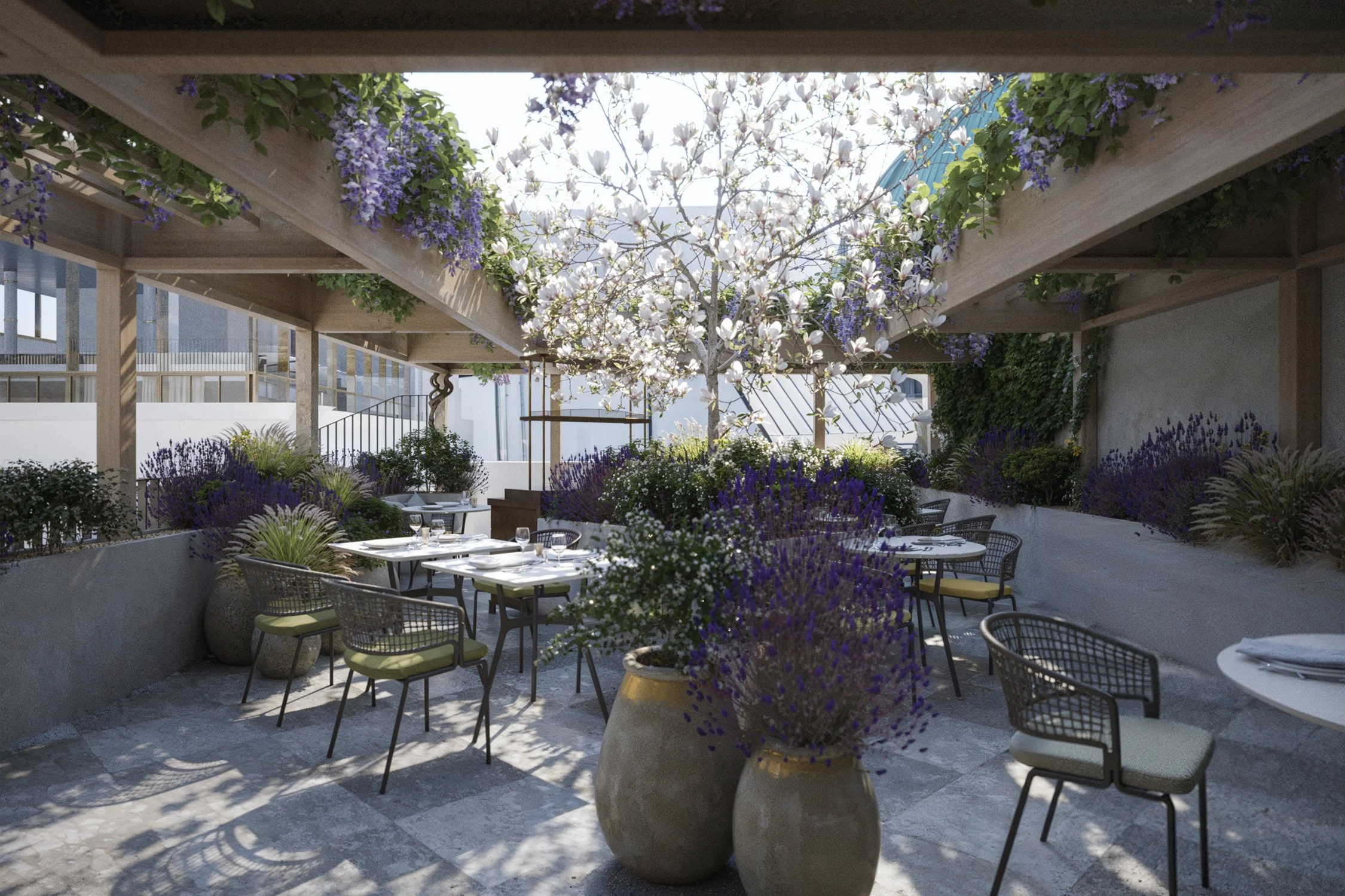 Outdoor dining area with tables, chairs, purple and white flowers, and a tree with white blossoms under a wooden pergola.