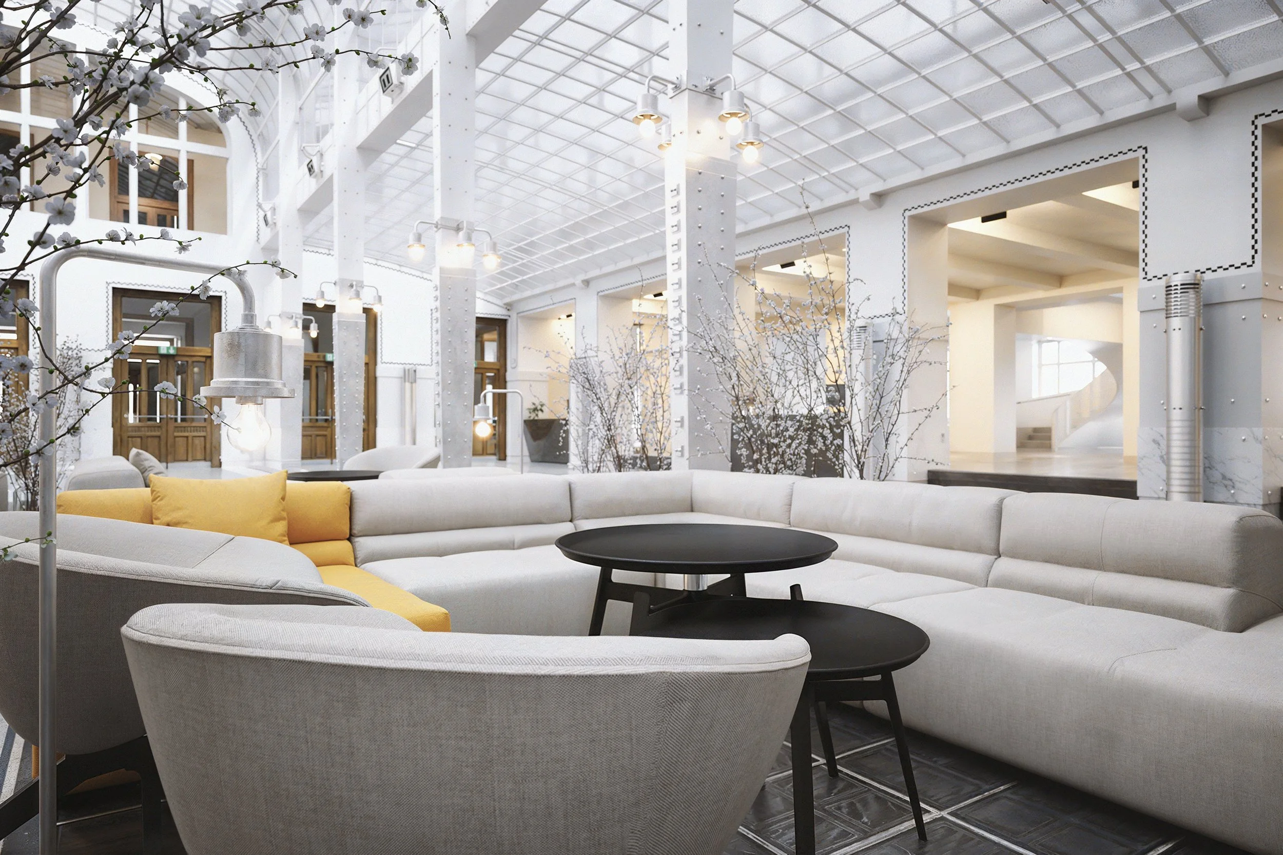 Modern hotel lobby with white walls, glass ceiling, and contemporary furniture, including a white sectional sofa with yellow cushions and black tables, decorated with flowering branches.
