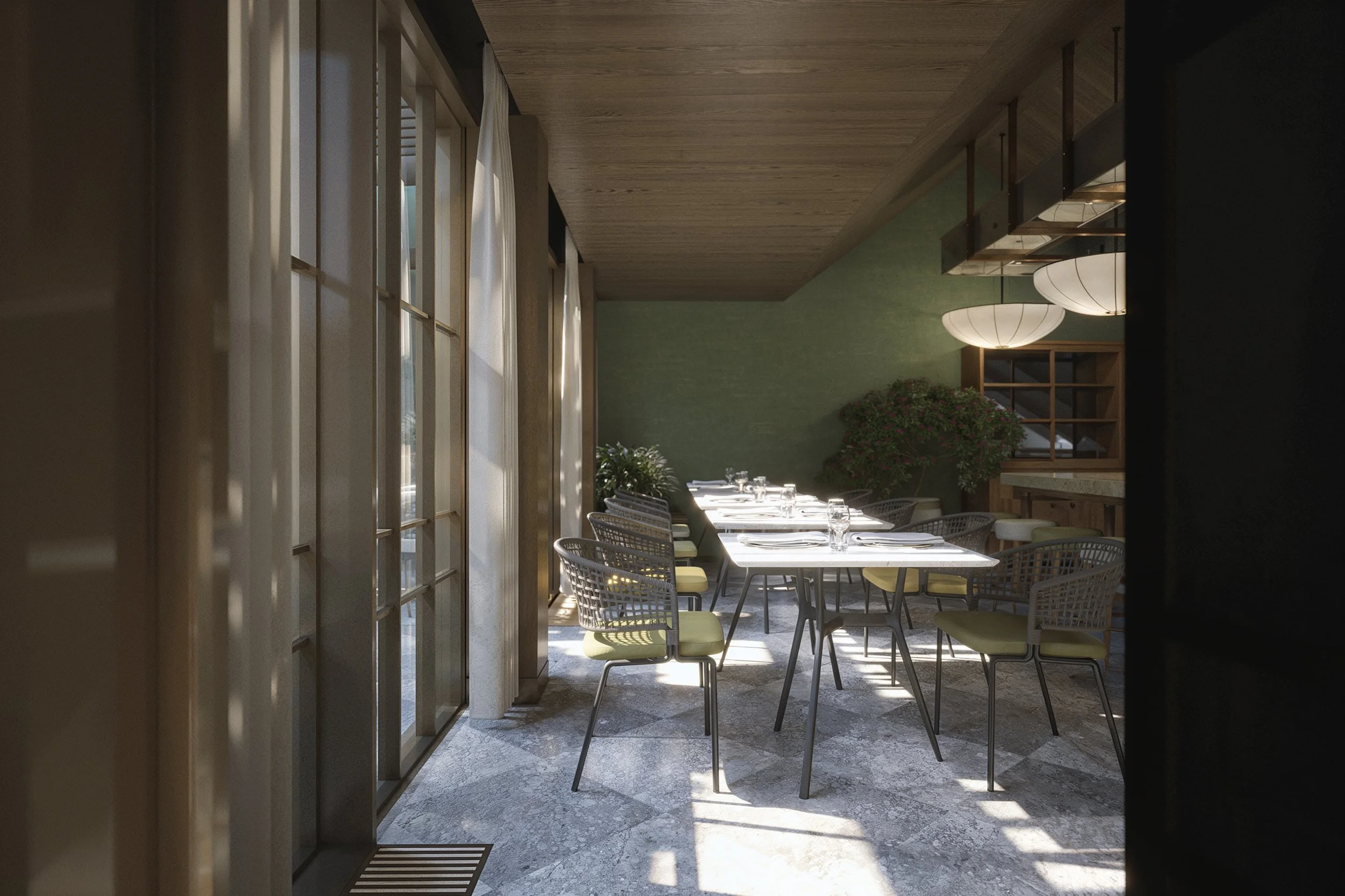 Empty restaurant dining area with tables set with glassware, surrounded by green walls, natural sunlight, and modern lighting fixtures.