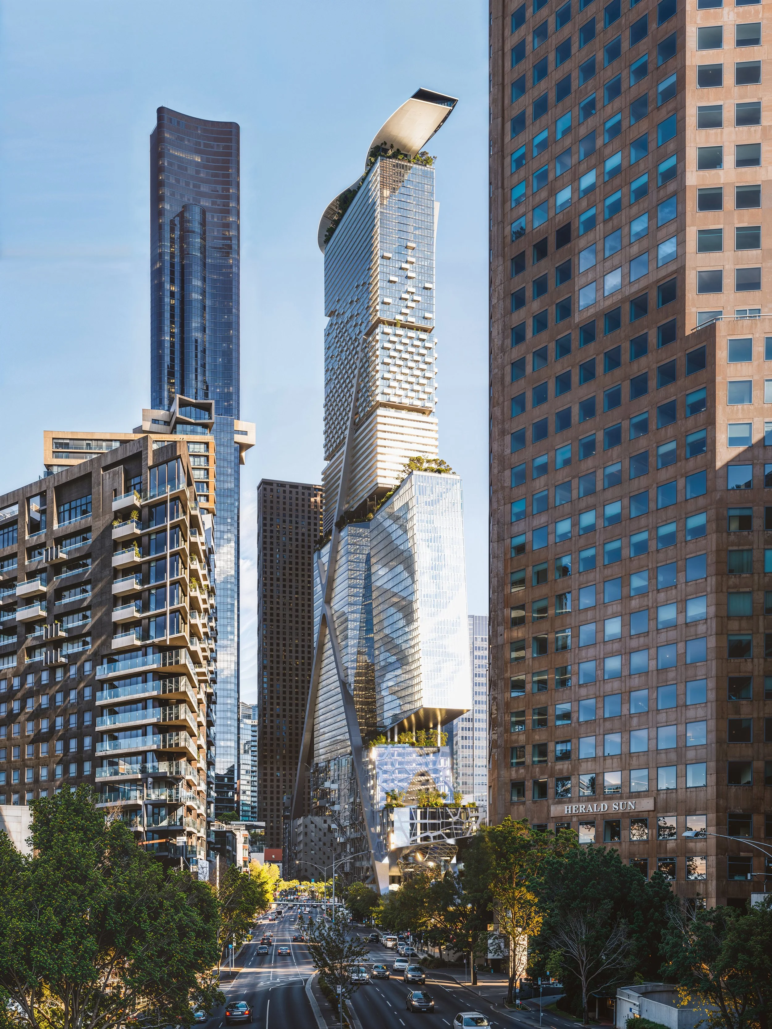 View of modern city skyscrapers, including a distinctive twisting skyscraper with a curved top, surrounded by tall buildings and busy streets with cars and trees.