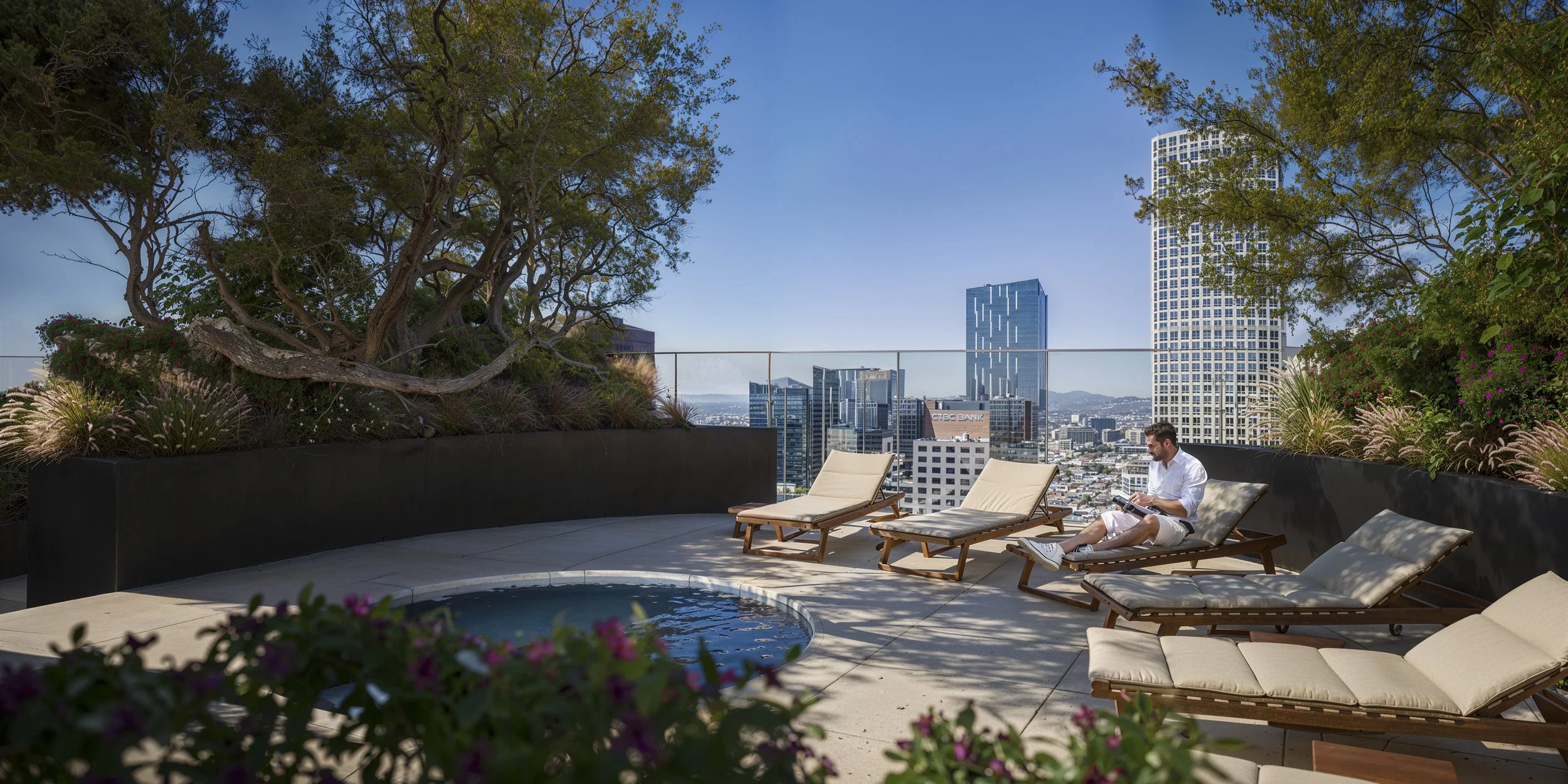 Rooftop terrace with lounge chairs, a small hot tub, and potted plants, overlooking a city skyline with tall buildings under a clear blue sky.