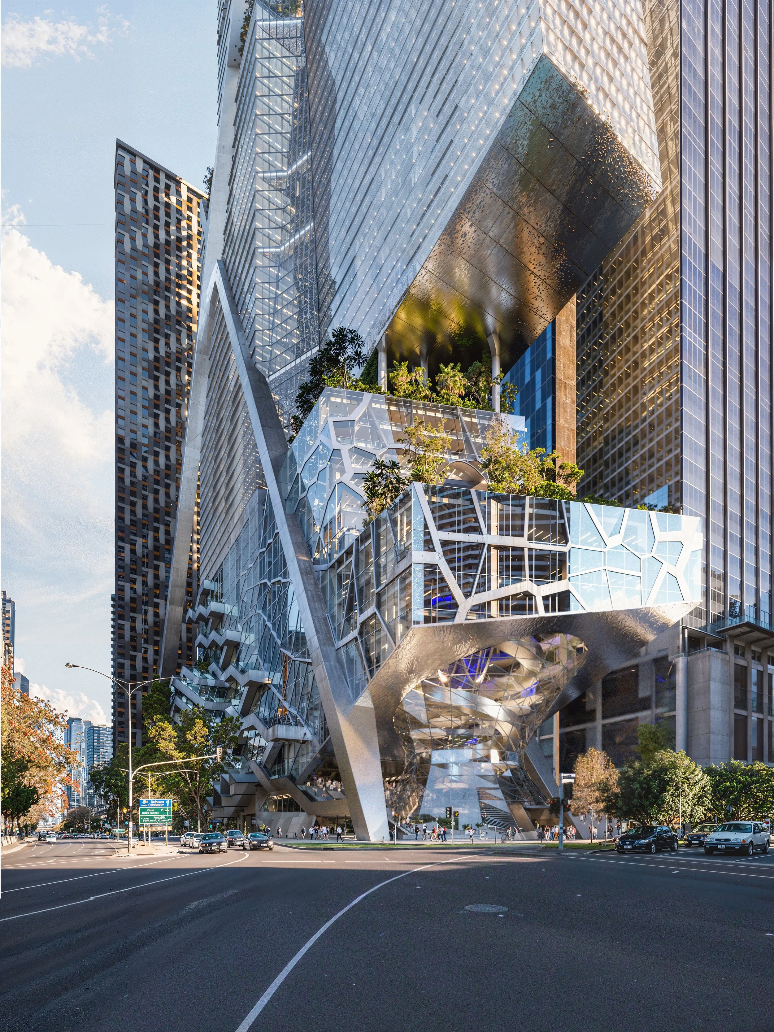 Modern skyscraper with glass and metal facade, featuring greenery on terraces, located on a city street with cars and trees.