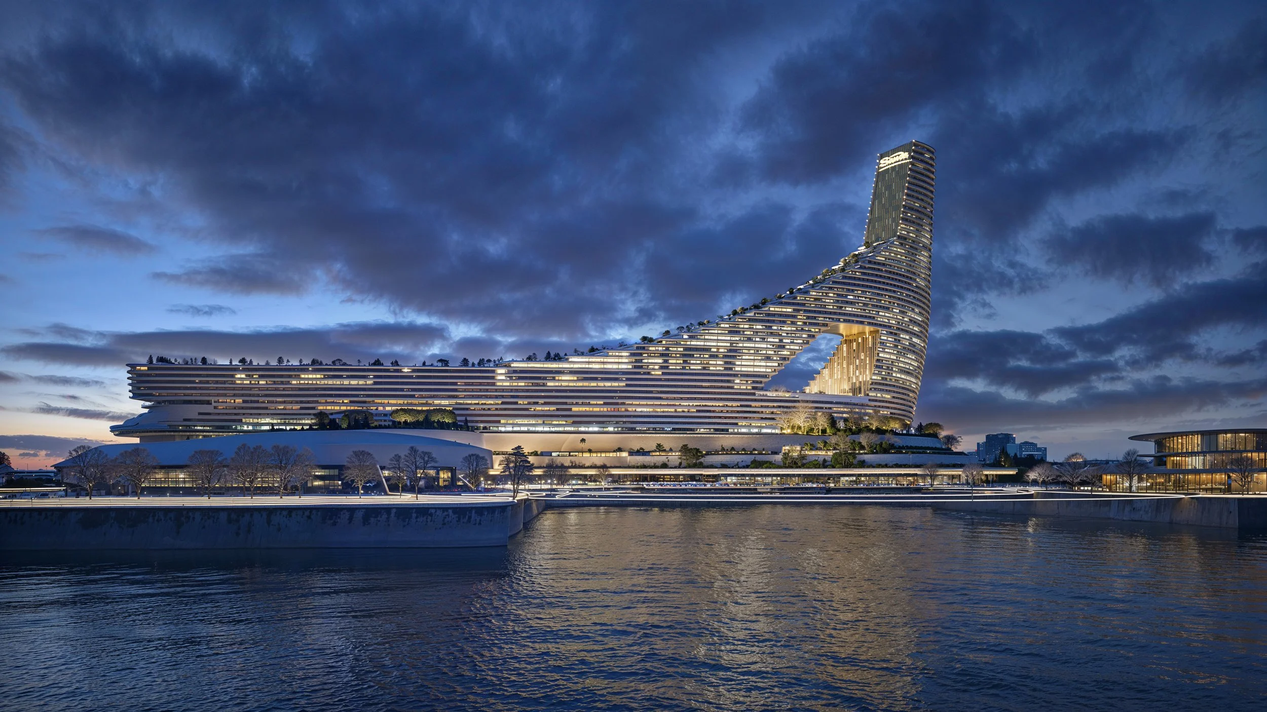 Modern Architectural Building with a Unique Curved Design at dusk near a body of water.
