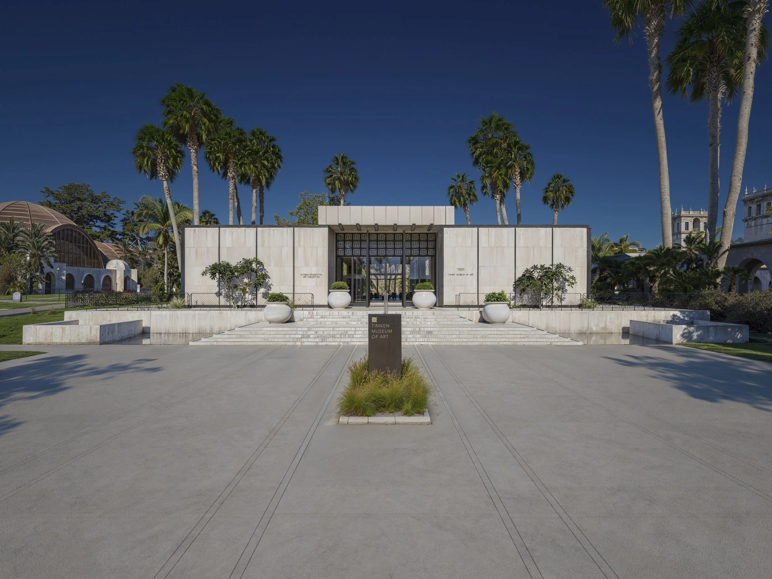 The Timken Museum of Art building with palm trees in San Diego, California, under a clear blue sky.