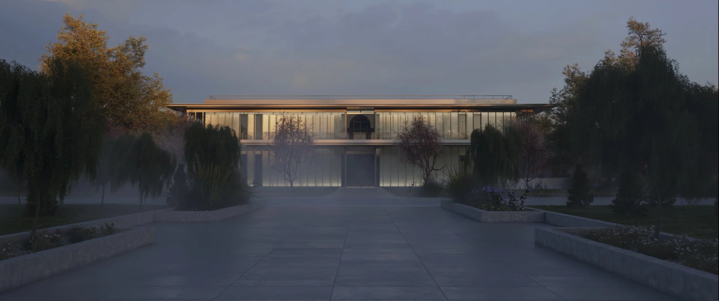 Modern building with glass facade, surrounded by trees and plants, with a paved walkway leading to it, during sunset or sunrise.