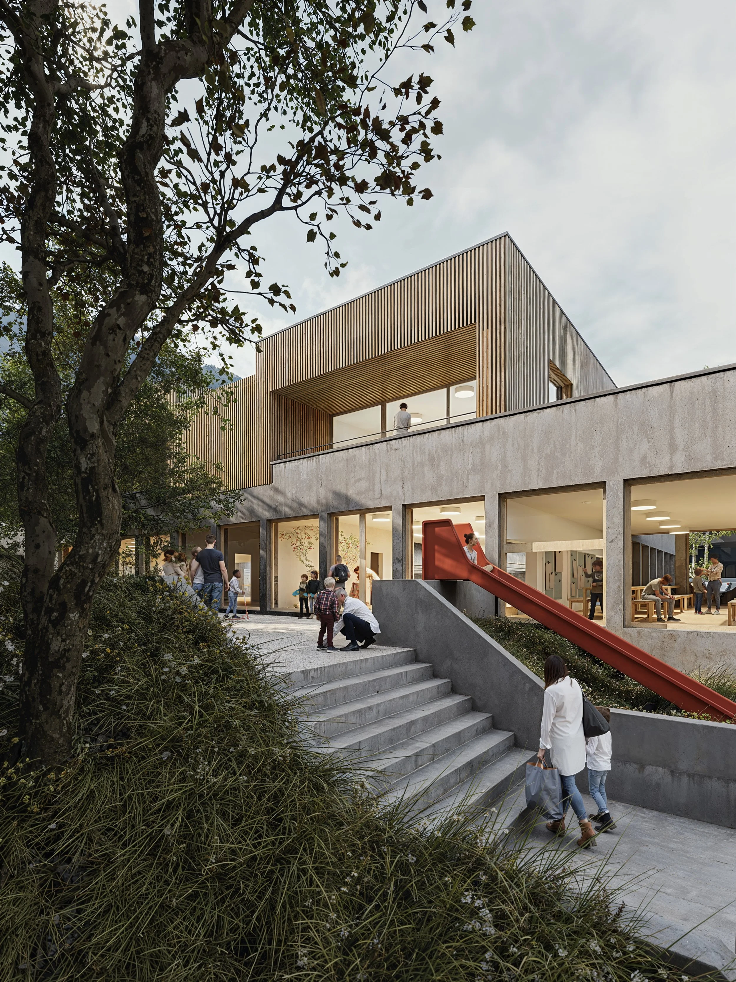 People gather outside a modern building with concrete and wood facade, a red slide, and an outdoor staircase, in a park-like setting with trees and greenery.