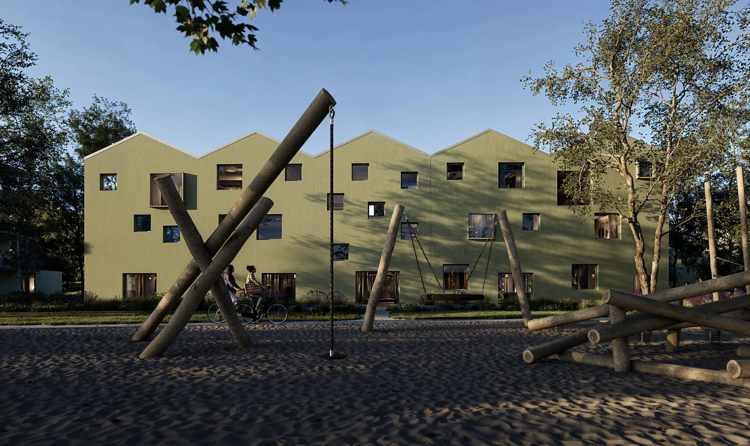 A modern green apartment building with playground equipment including swings and logs in the foreground, with children riding bikes and trees around.