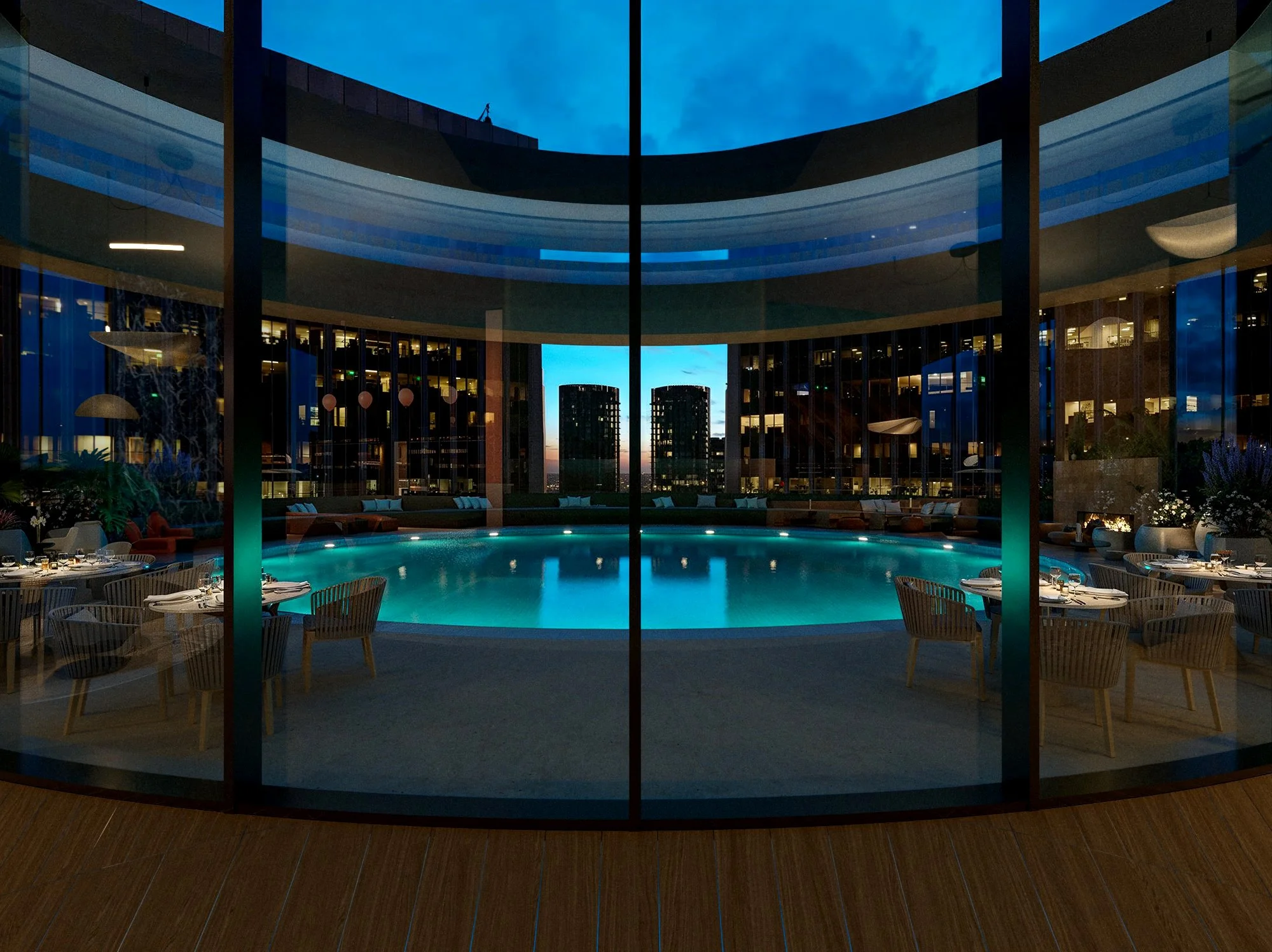 Indoor swimming pool area at dusk with glass walls, surrounding seating, and cityscape view.