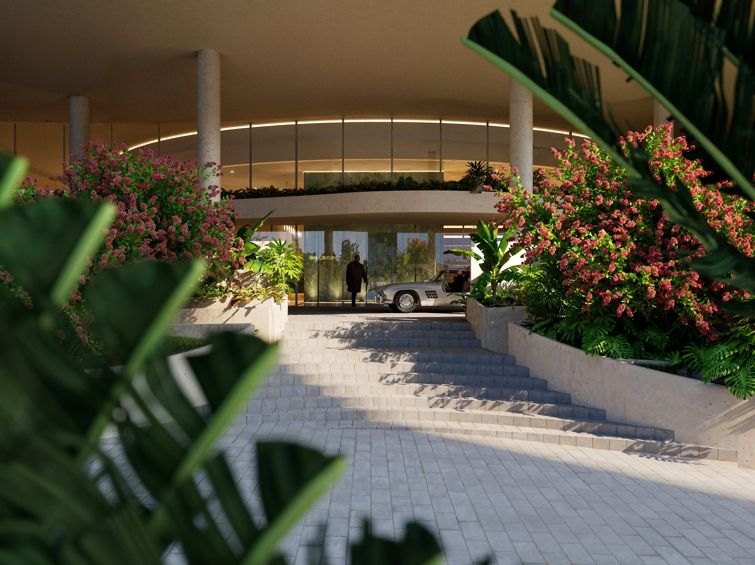 Luxury hotel entrance surrounded by lush pink and green tropical plants, modern curved architecture, and a vintage silver car parked near the door.