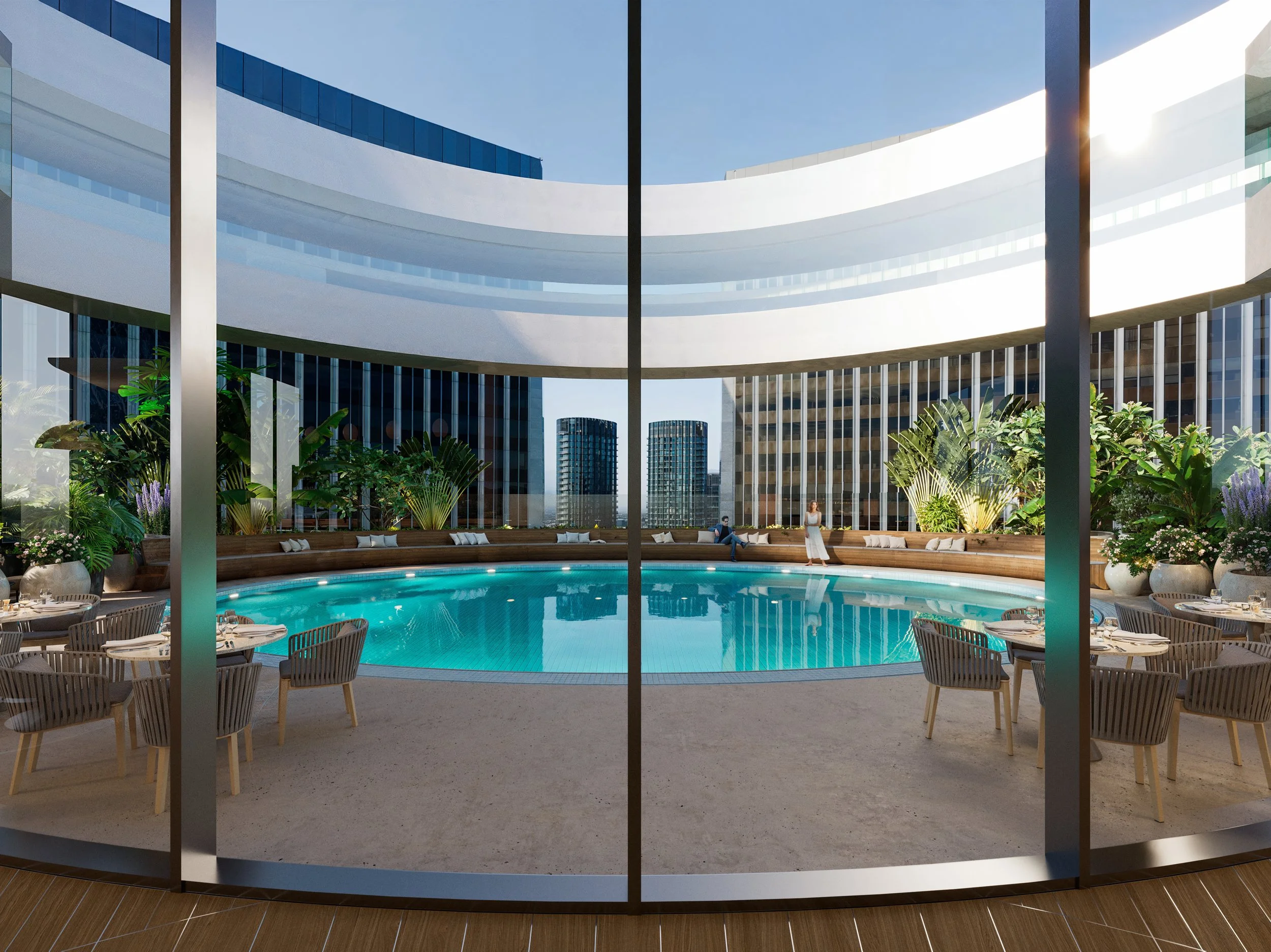 View of a rooftop pool area with lounge chairs, potted plants, and modern high-rise buildings in the background, seen through large glass windows.