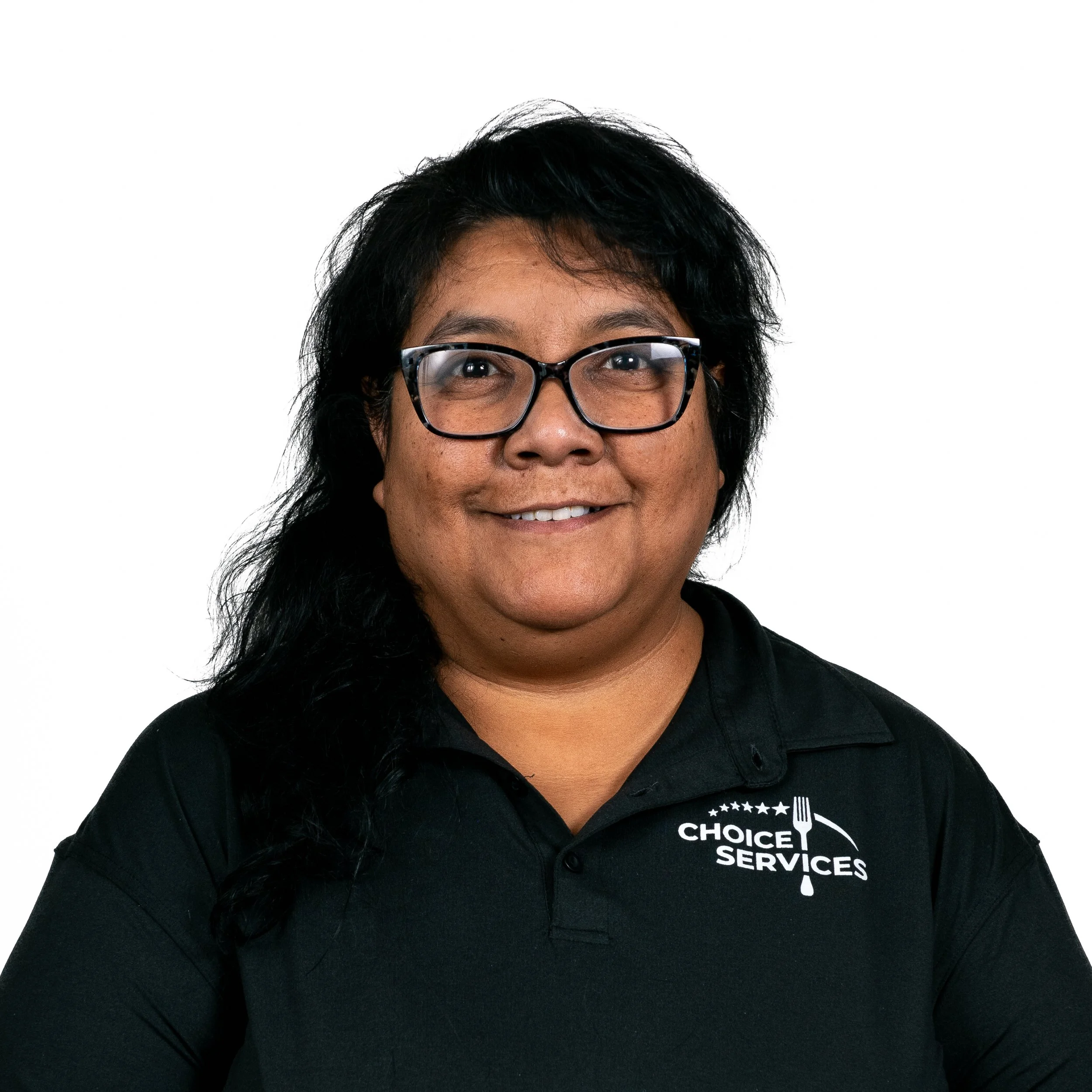Portrait of a woman with glasses, smiling, wearing a black polo shirt with a logo for 'Choice Services.'
