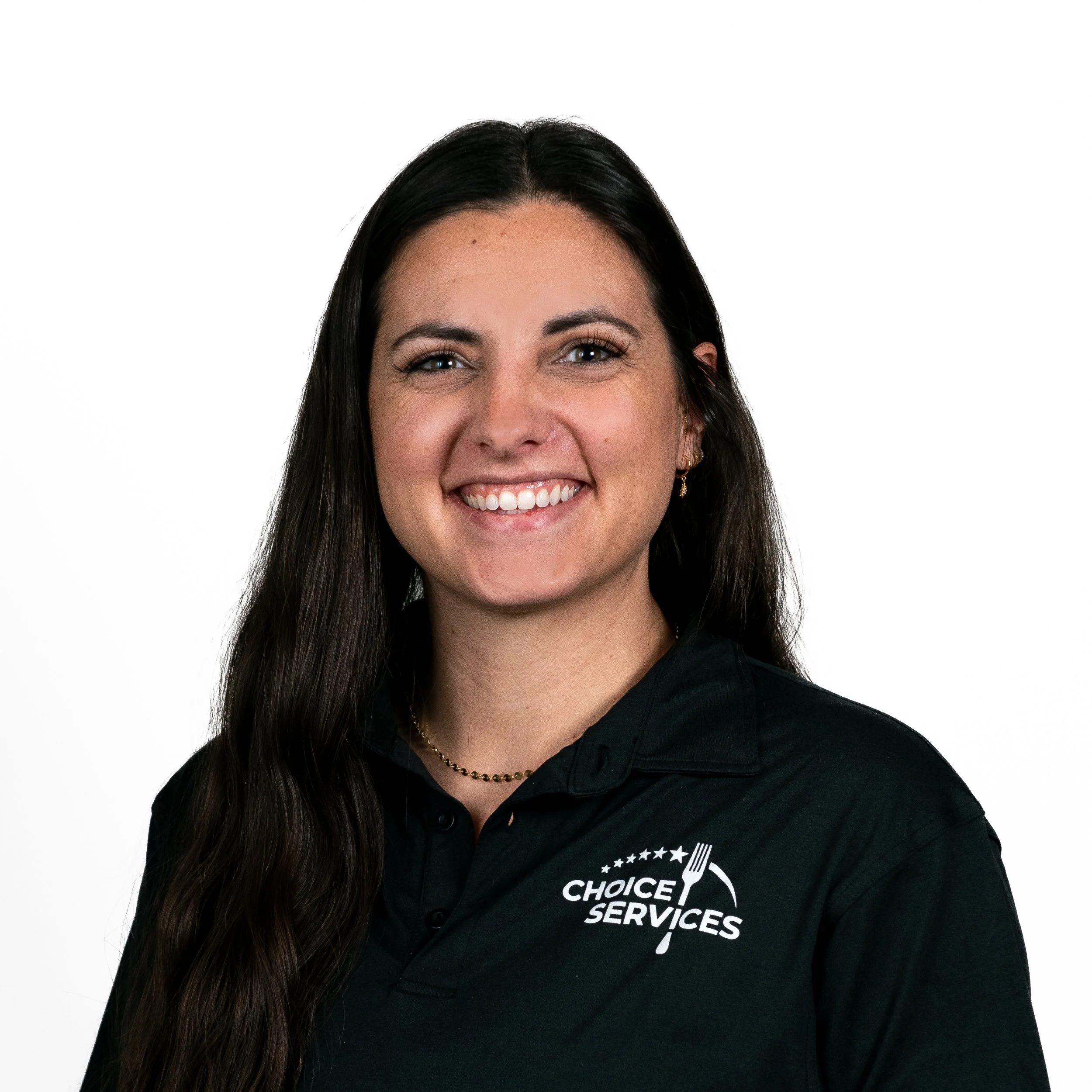 A woman with long dark hair smiling, wearing a black polo shirt with a 'Choice Services' logo.