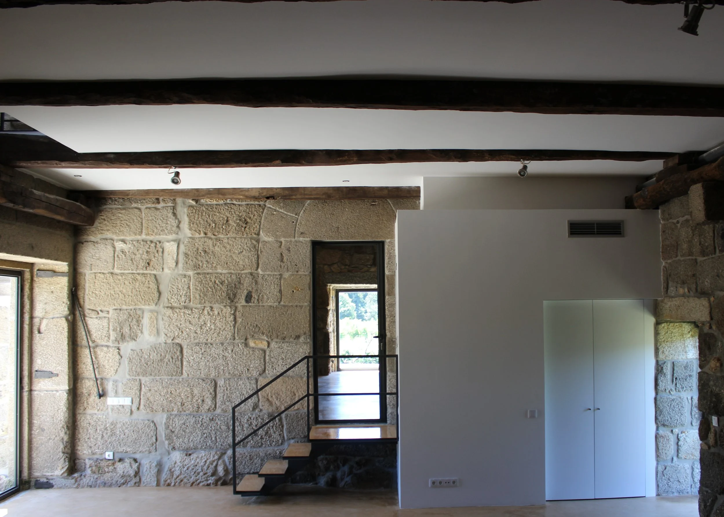 Espaço interior em habitação unifamiliar reabilitada, estrutura existente em pedra e escada interior — GAUG