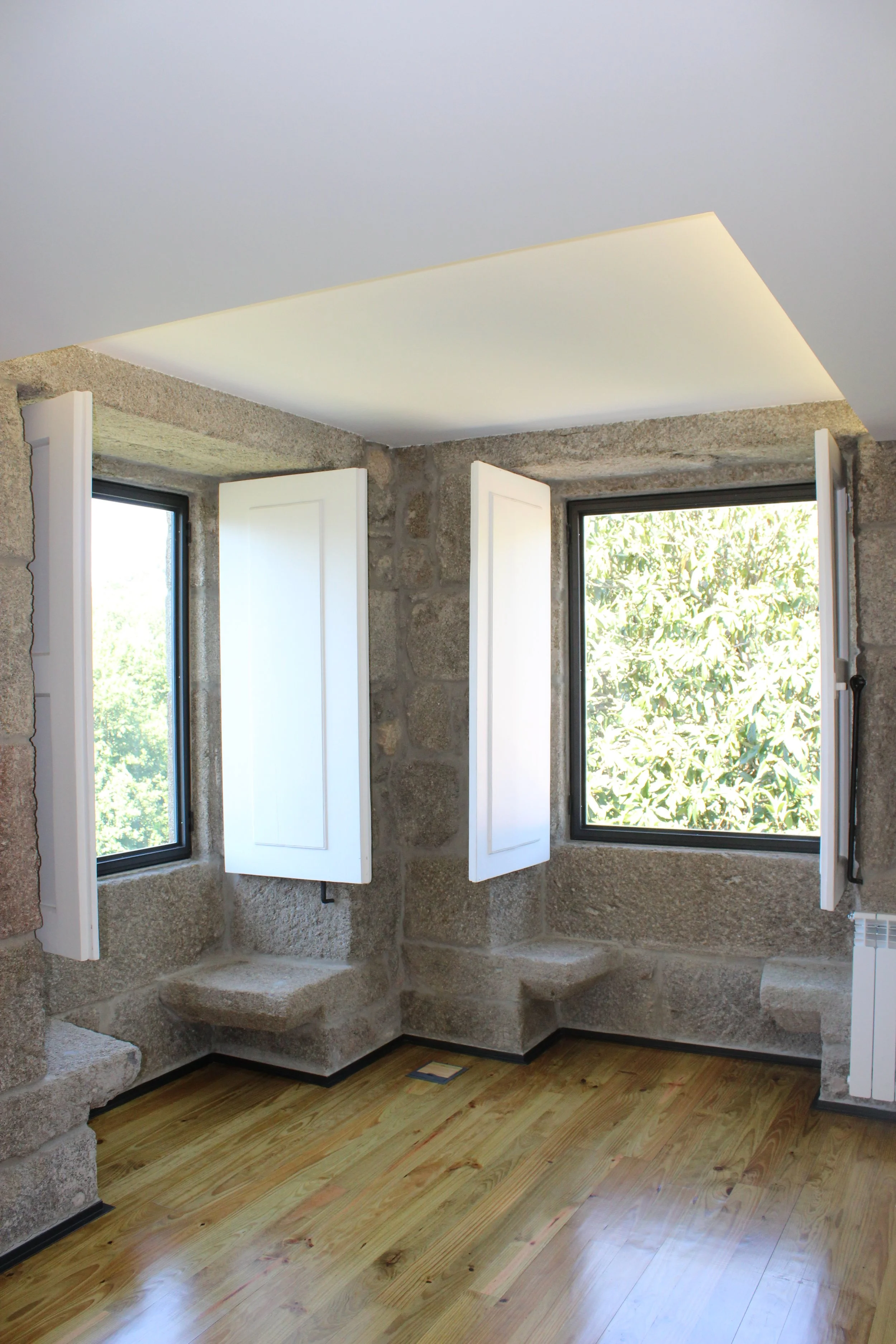 Espaço interior em habitação unifamiliar reabilitada, paredes em pedra e vãos com portadas — GAUG