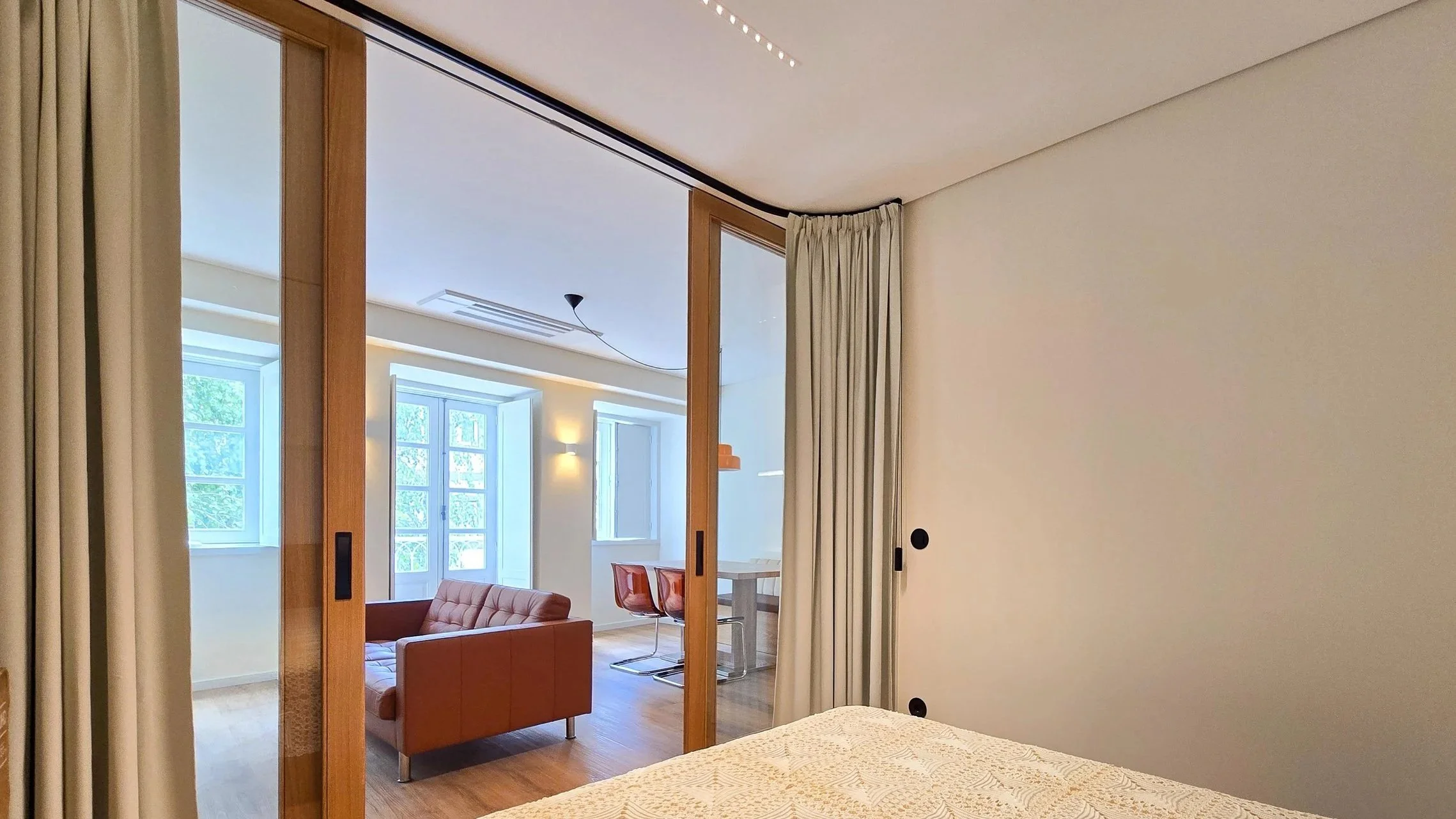 Relação entre quarto e zona social em apartamento remodelado, portas de correr e continuidade espacial — GAUG