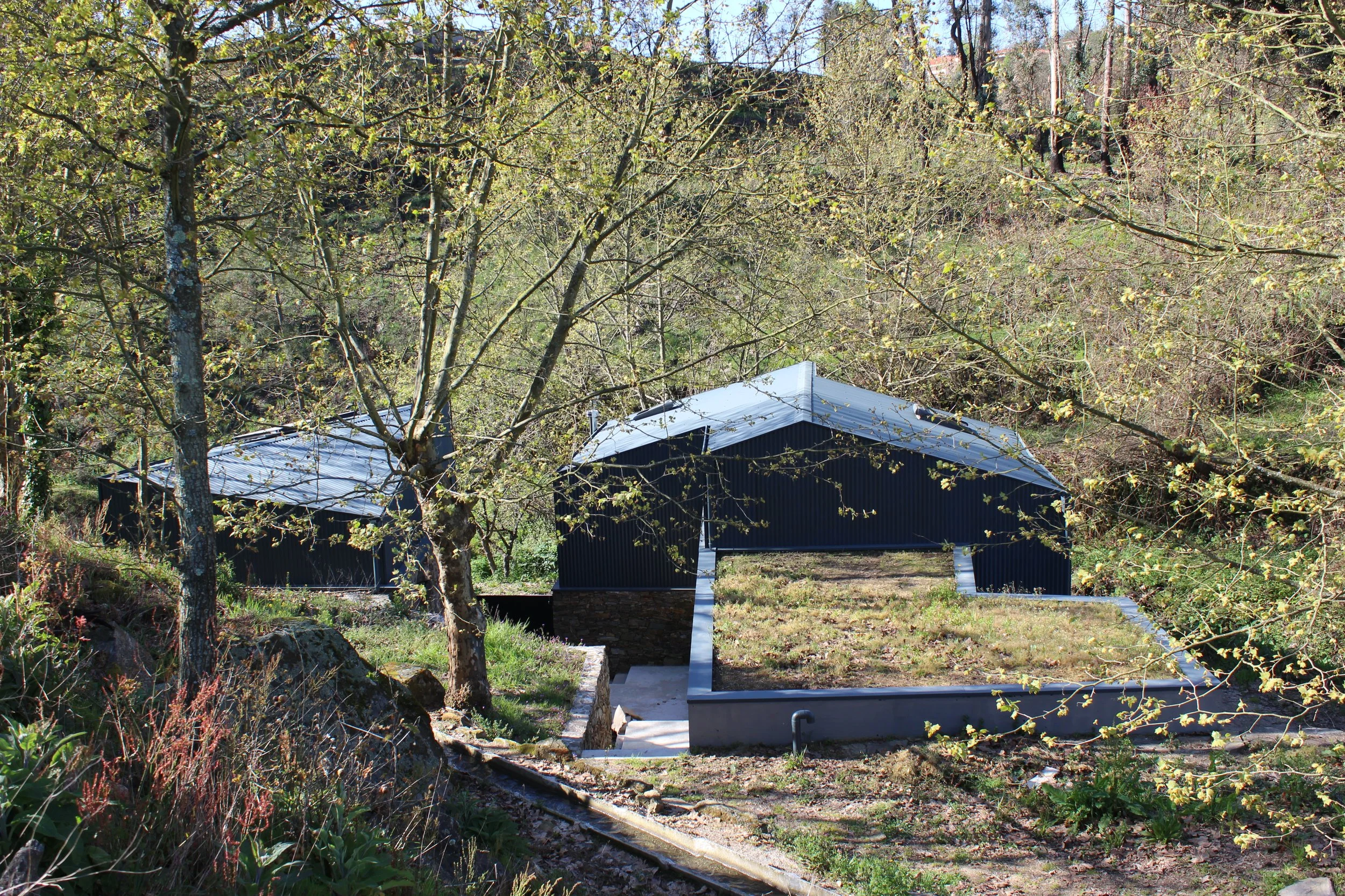 Vista geral de habitação unifamiliar integrada na paisagem, com volumes e cobertura — GAUG