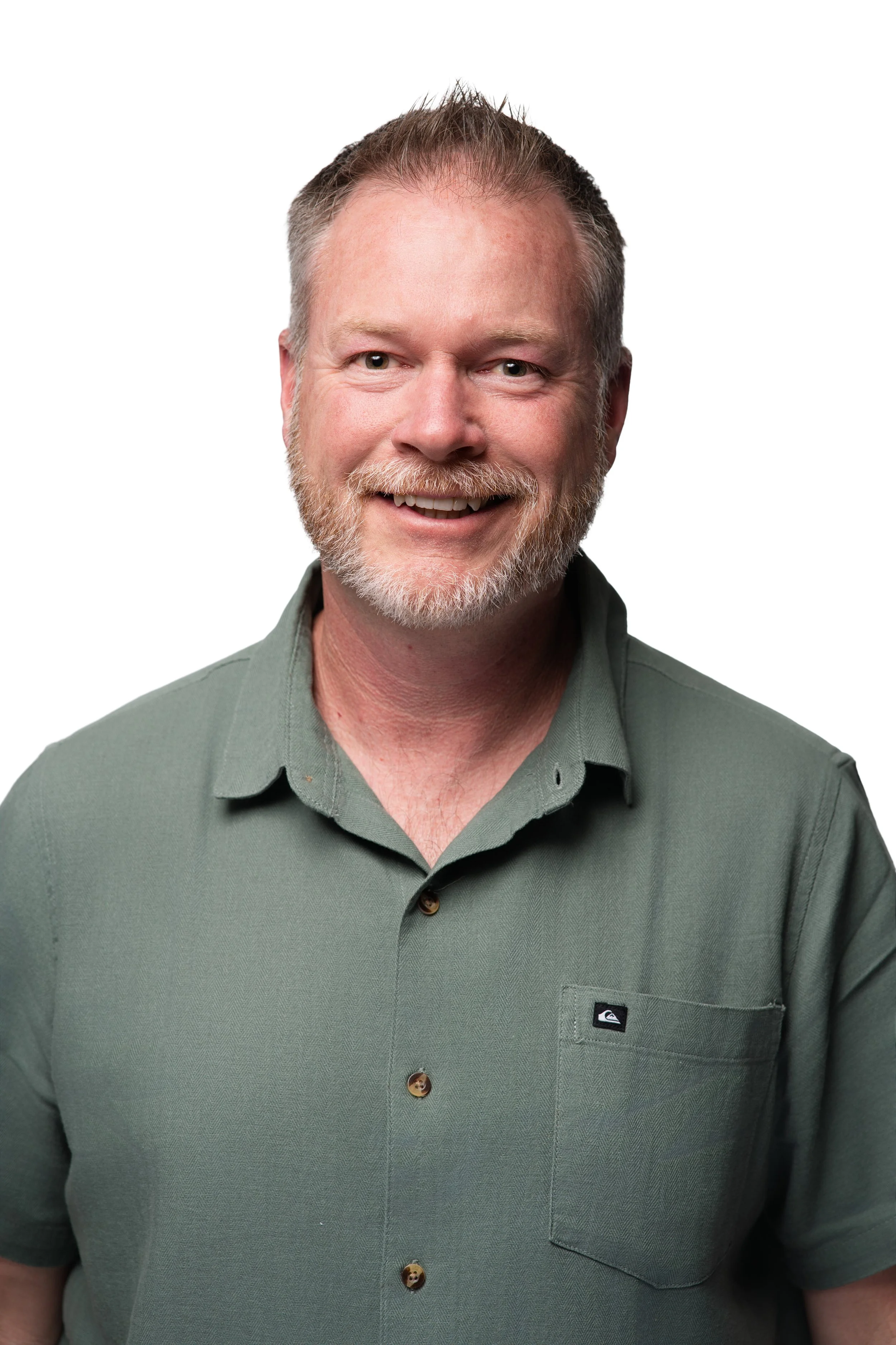 A smiling middle-aged man with a beard and short hair, wearing a green button-up shirt, on a white background.