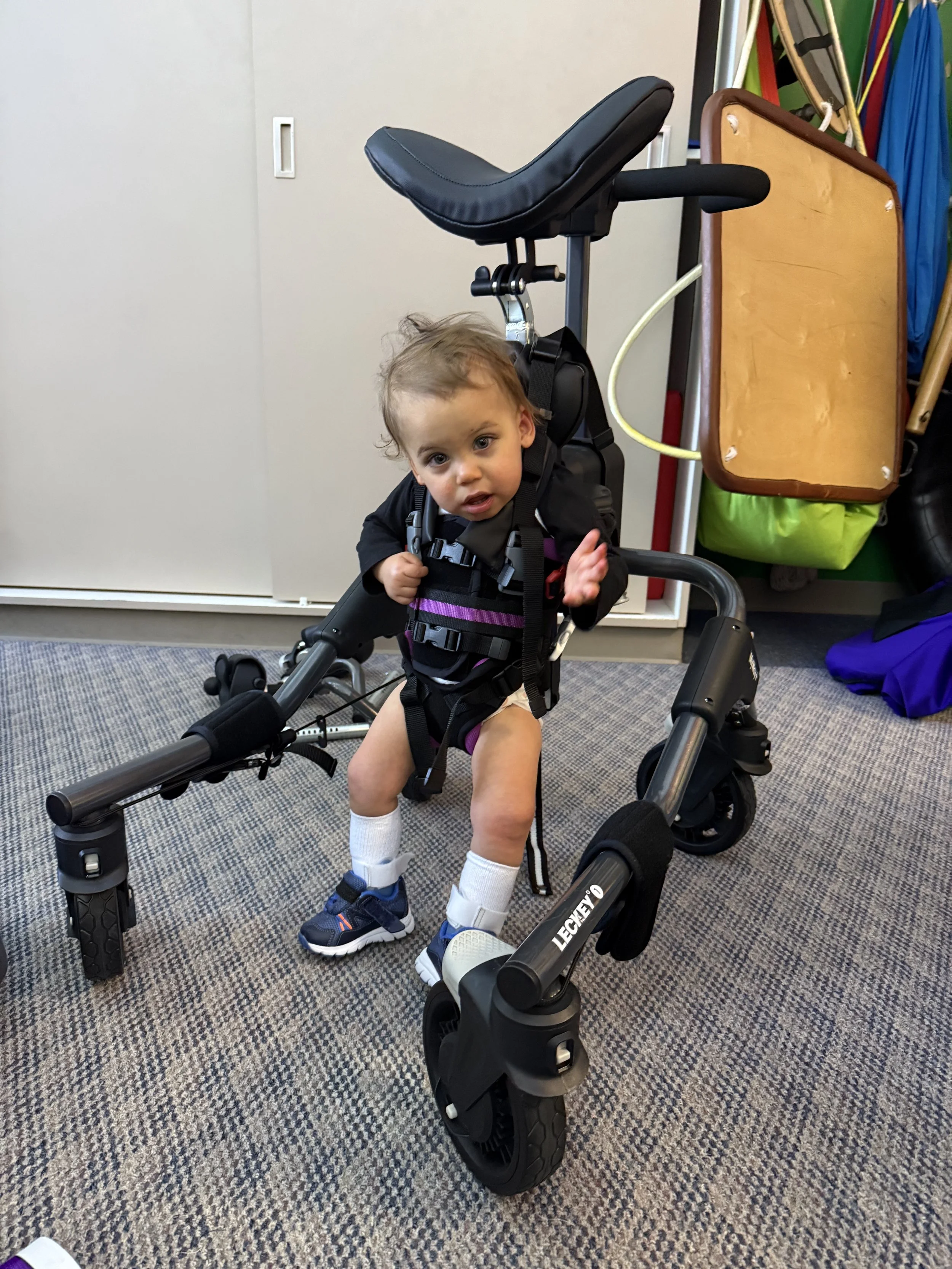 Using some equipment to encourage him to put weight on his legs.