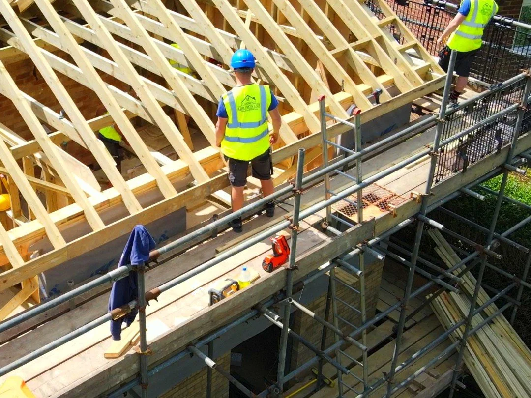 Construction team working on roof framing during a residential build.
