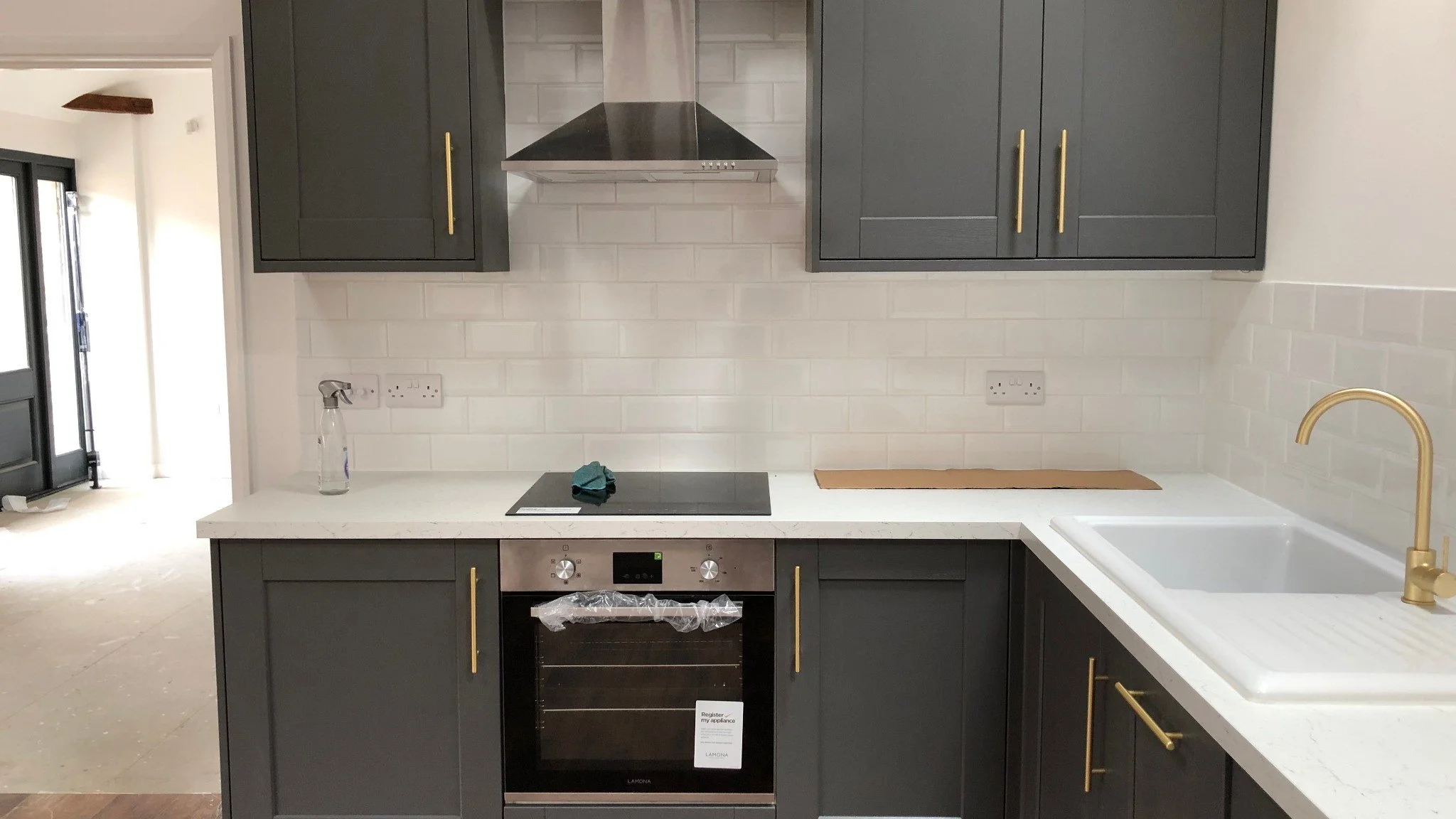 Modern kitchen interior with fitted cabinets, tiled floor and natural light from feature windows.