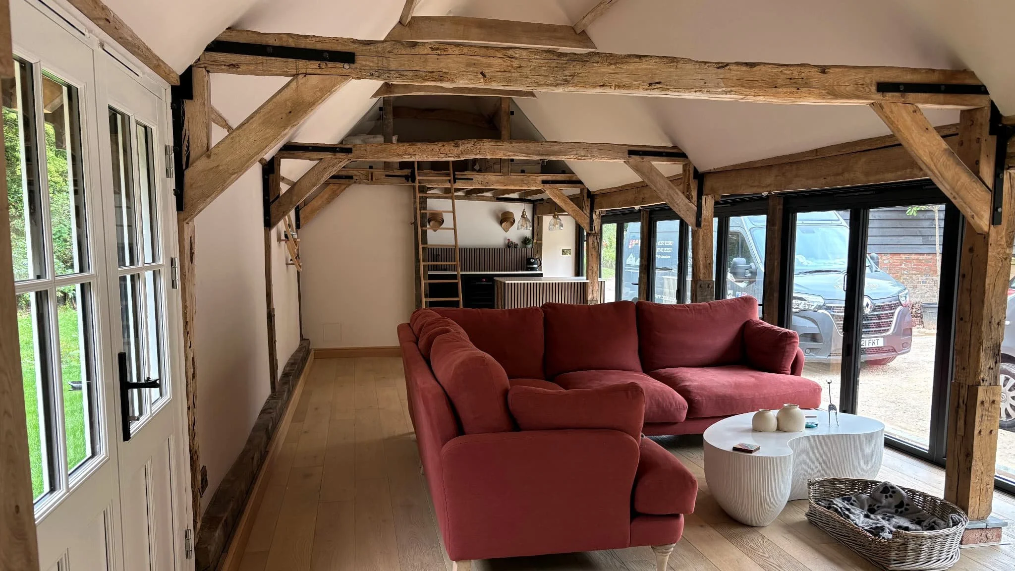 Extended living space in a Sussex home with exposed timber beams and large glazed doors