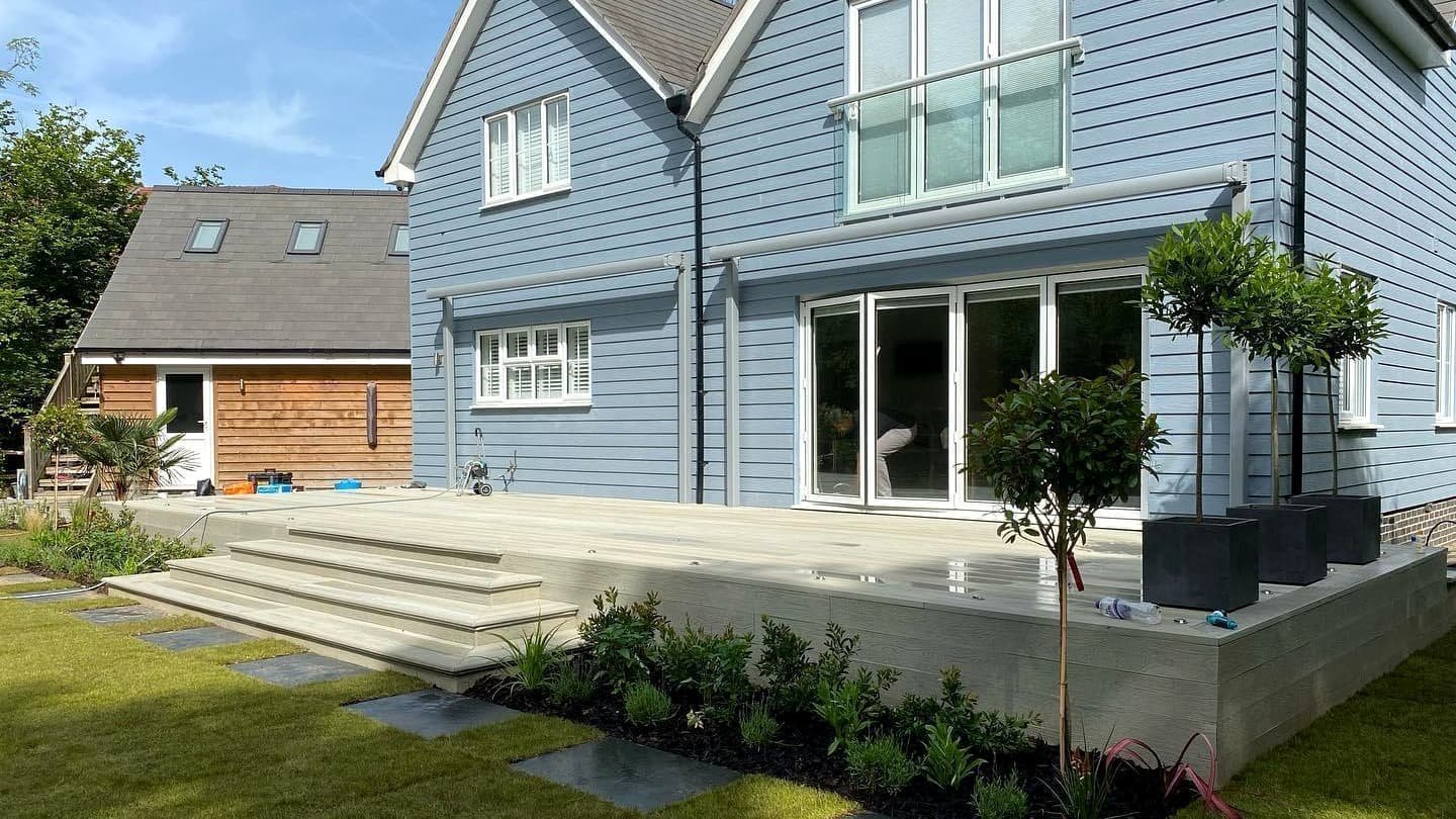 Completed Sussex home with blue timber cladding, large garden terrace and landscaped garden