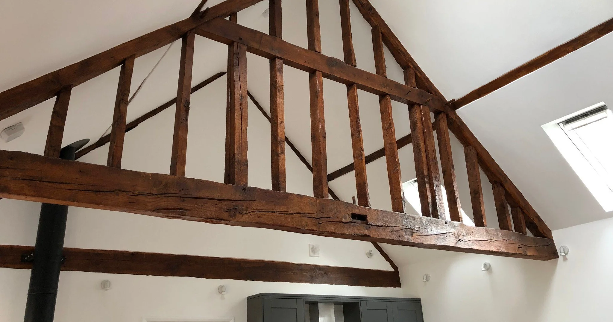 Renovated interior with exposed original timber beams and bright modern finishes.