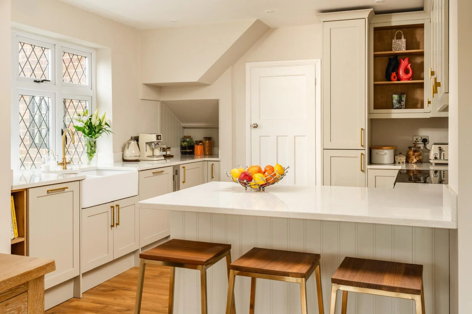 Completed kitchen renovation with cream cabinetry, island seating and brass fittings in a Sussex home
