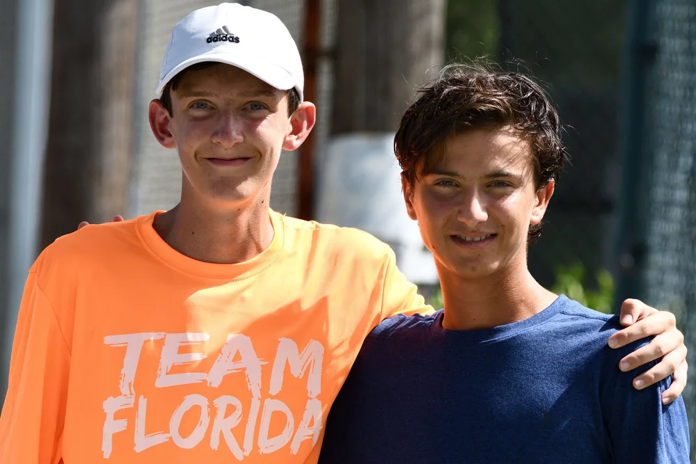 Two young players smiling outdoors, one in a Team Florida shirt