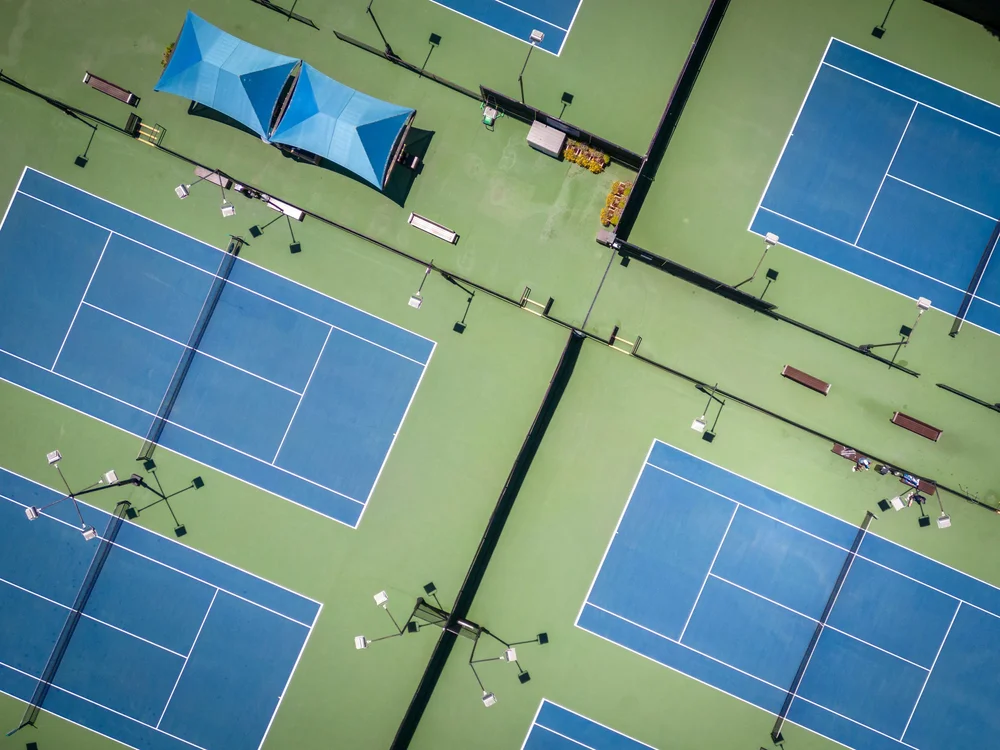 Aerial view of several blue and green tennis courts