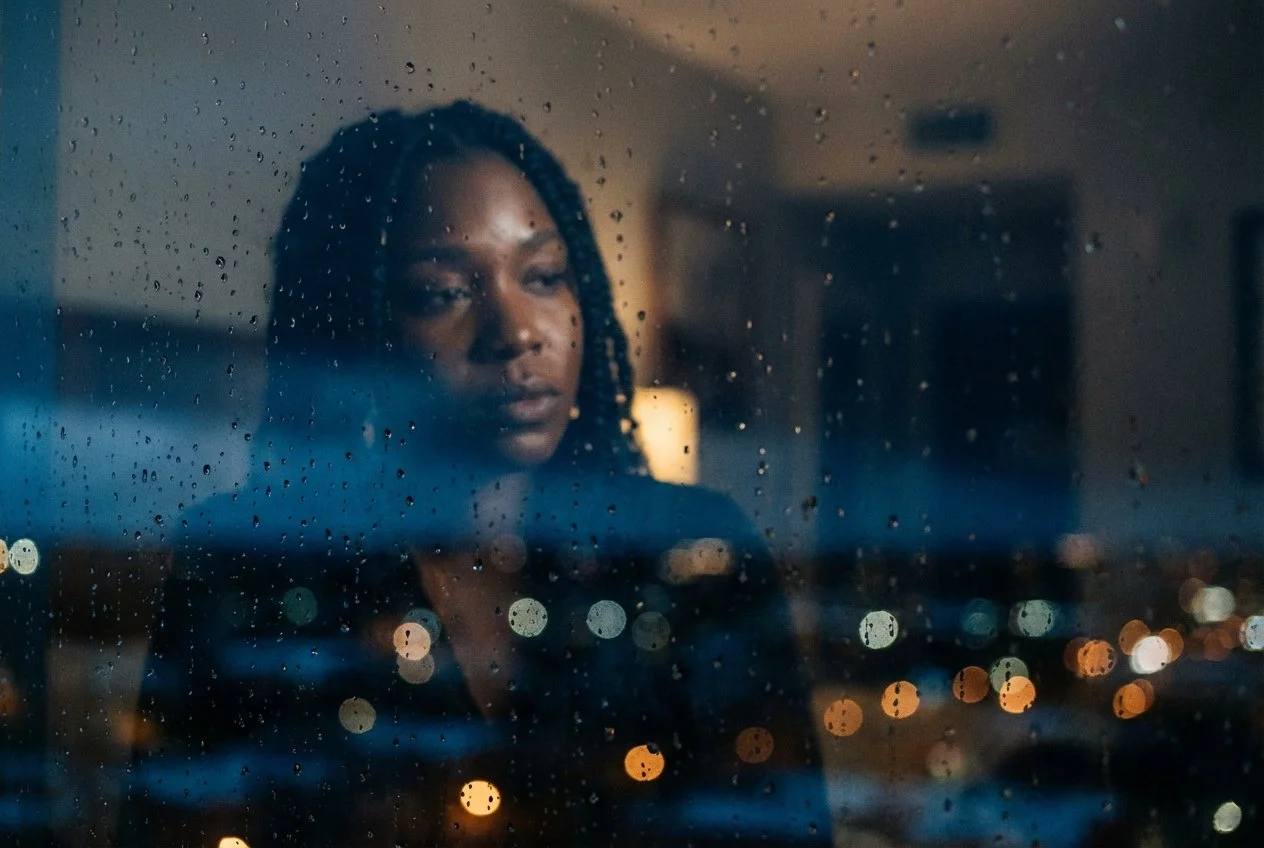 black woman looking through a window