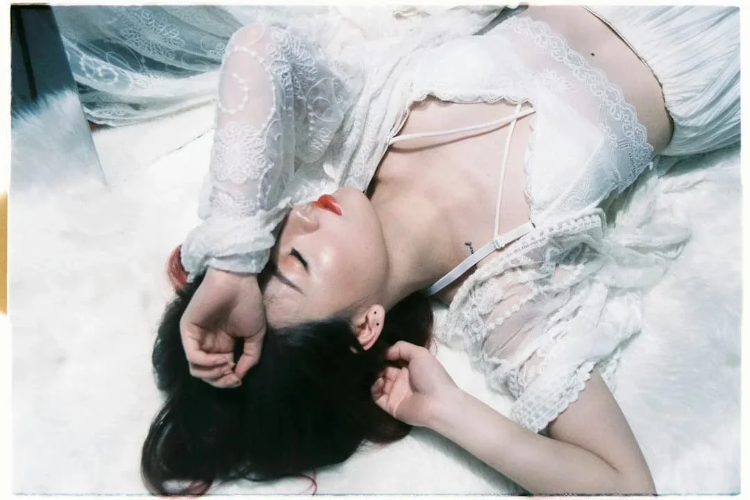 Woman lying down with her arm over her face during an emotional moment