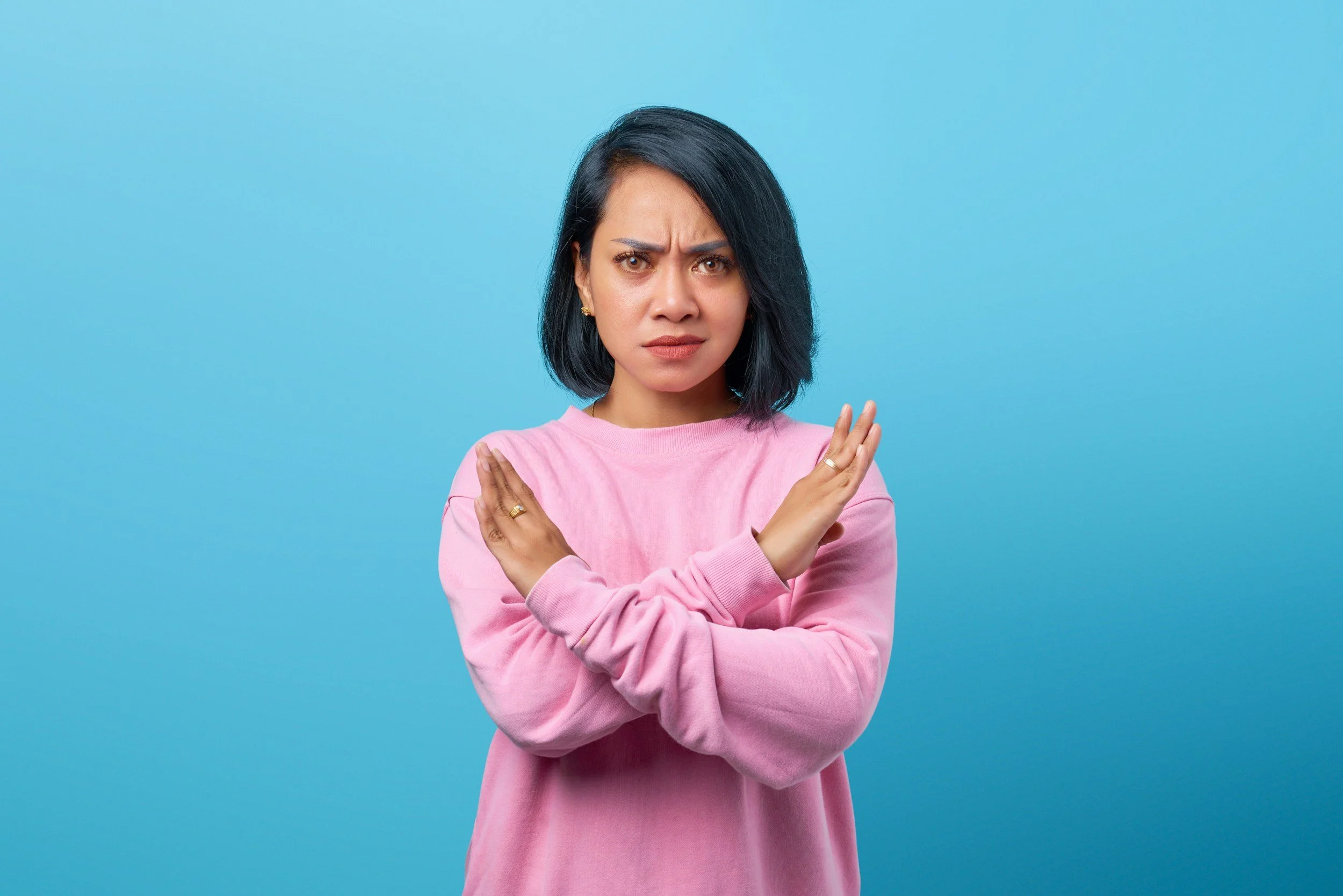 Woman firmly crossing her arms representing healthy boundaries and self-advocacy through therapy for women