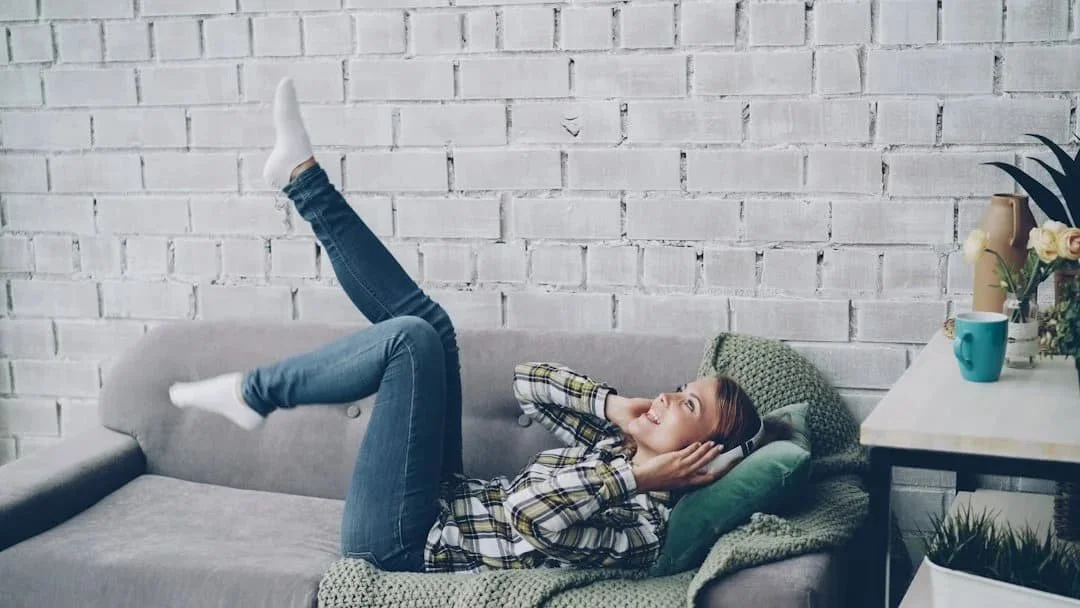 Woman relaxing comfortably on her couch at home representing the ease of anxiety therapy