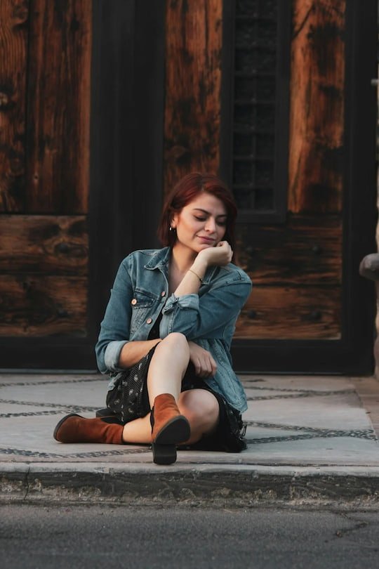 Woman sitting alone looking reflective. Anxiety and trauma therapy for women.