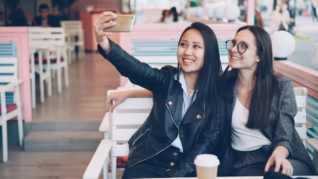 Two women smiling and taking a selfie representing connection and joy after trauma healing in Phoenix AZ