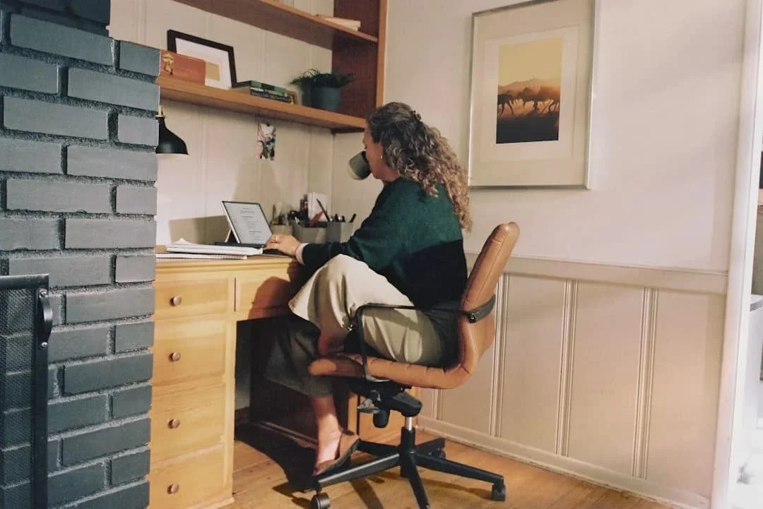 Woman working at a home desk with coffee representing the high-achieving women who seek virtual therapy in Arizona