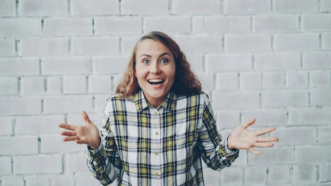 Woman reacting with a surprised expression and her hands raised